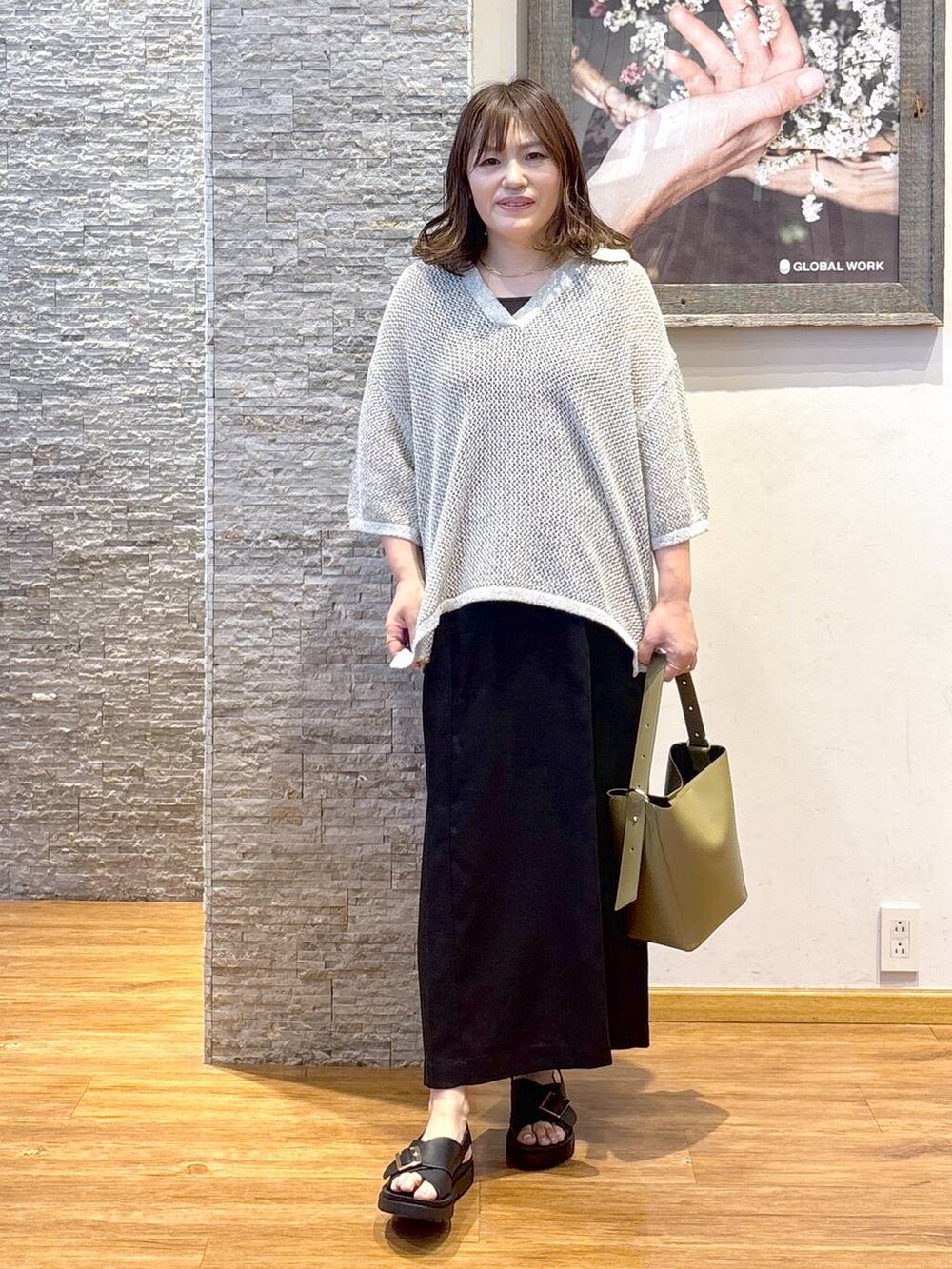 グリーン系のショルダーバッグ、ブラウン系のタンクトップ、ブラック系のサンダルを着用したレディースの夏コーディネートの4枚目の写真