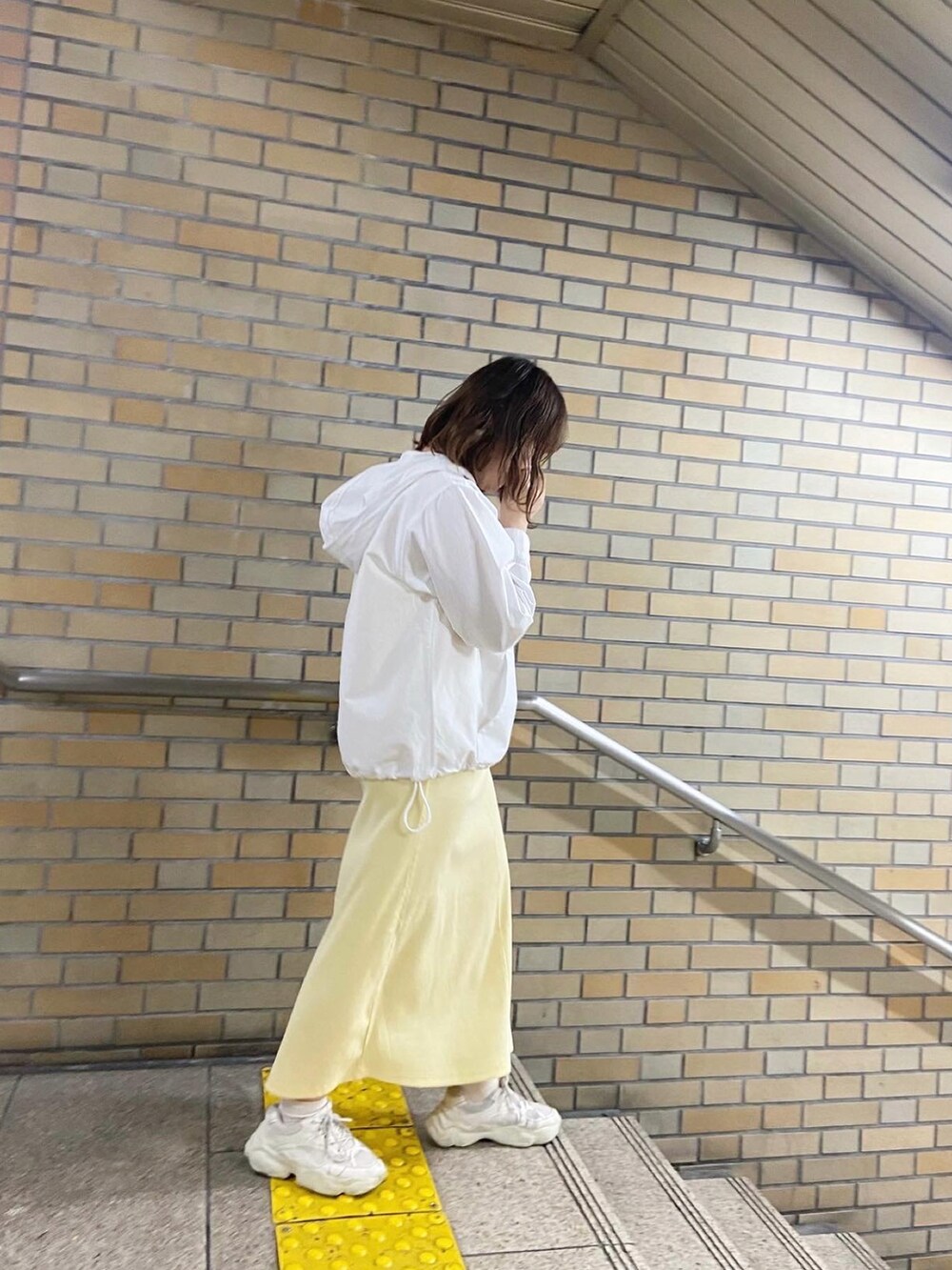 ホワイト系のパーカー、ホワイト系のショルダーバッグ、イエロー系のワンピースを着用したレディースの春コーディネートの2枚目の写真
