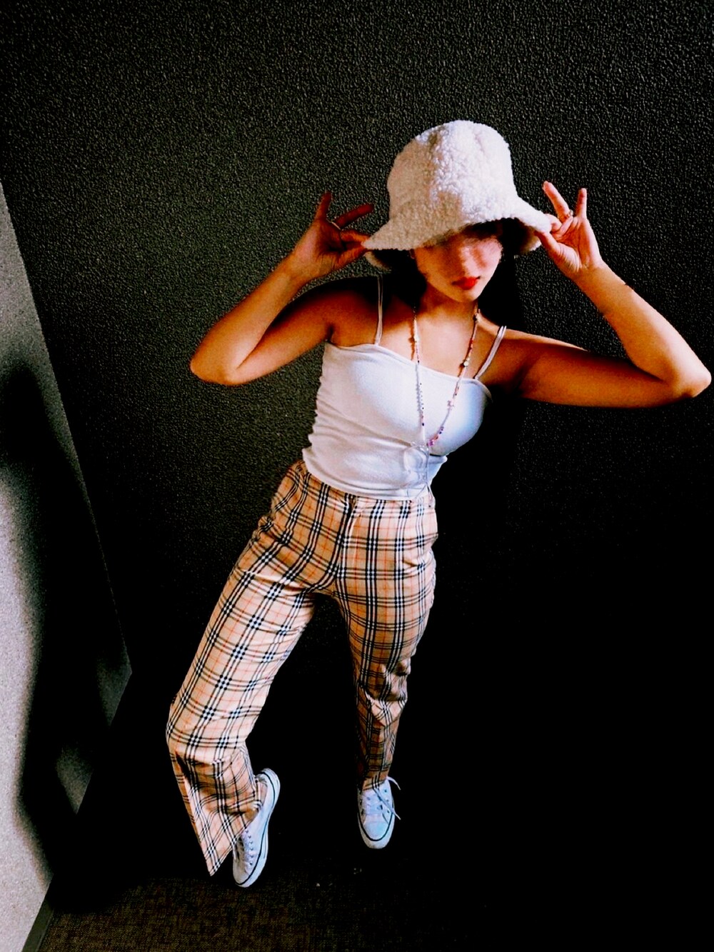 ホワイト系のキャミソール、ベージュ系のスラックス、ホワイト系のスニーカーを着用したレディースの秋コーディネートの2枚目の写真