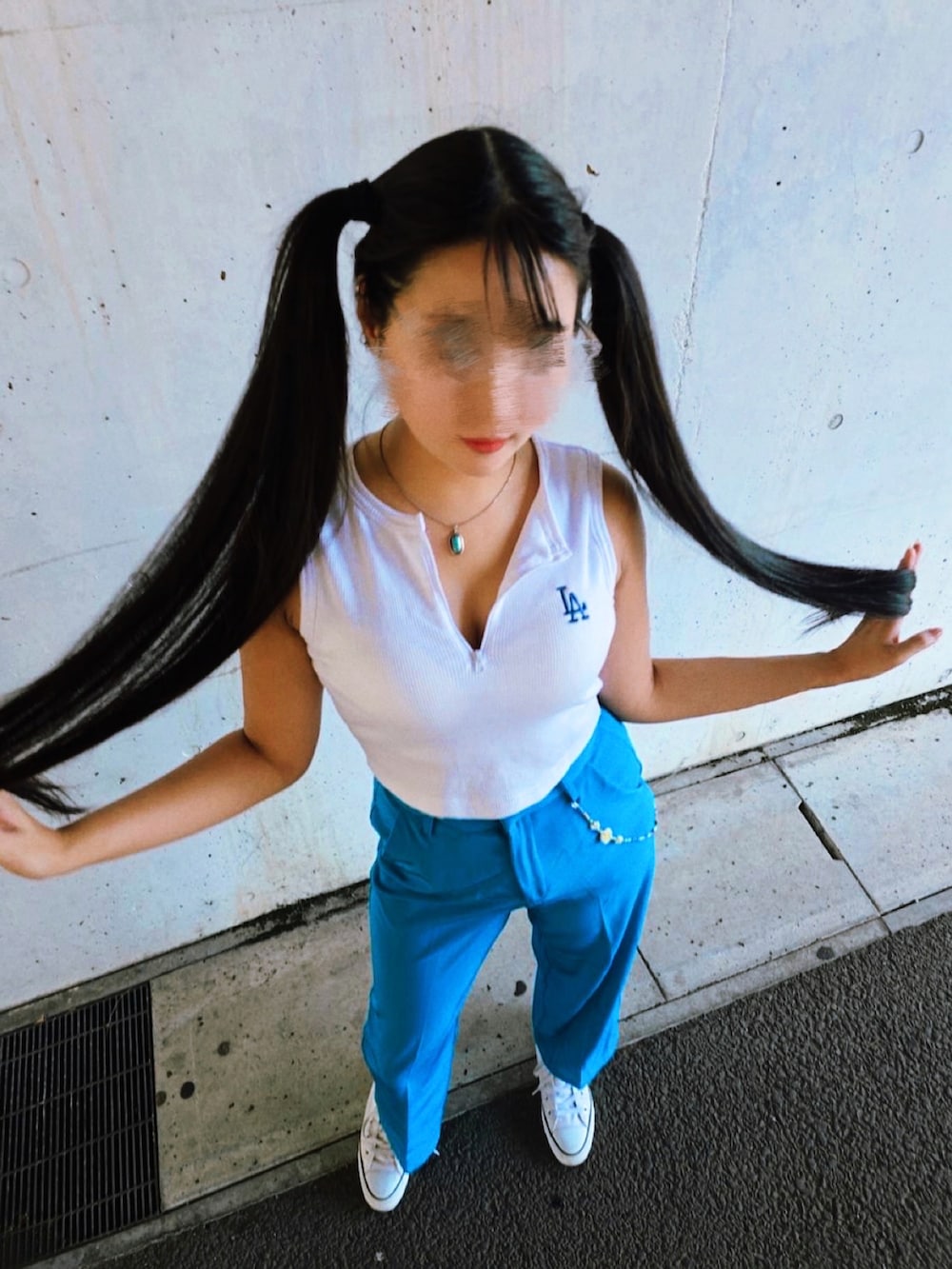 ホワイト系のタンクトップ、ブルー系のスラックス、ホワイト系のスニーカーを着用したレディースの秋コーディネートの2枚目の写真