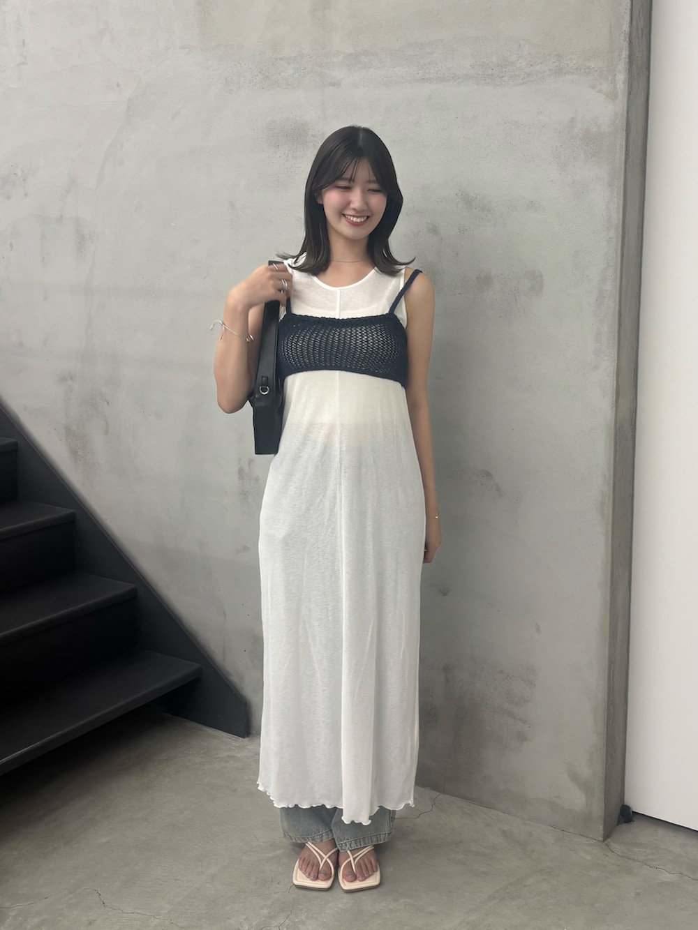 ホワイト系のワンピース、ブルー系のデニムパンツ、ブルー系のベストを着用したレディースの夏コーディネートの2枚目の写真