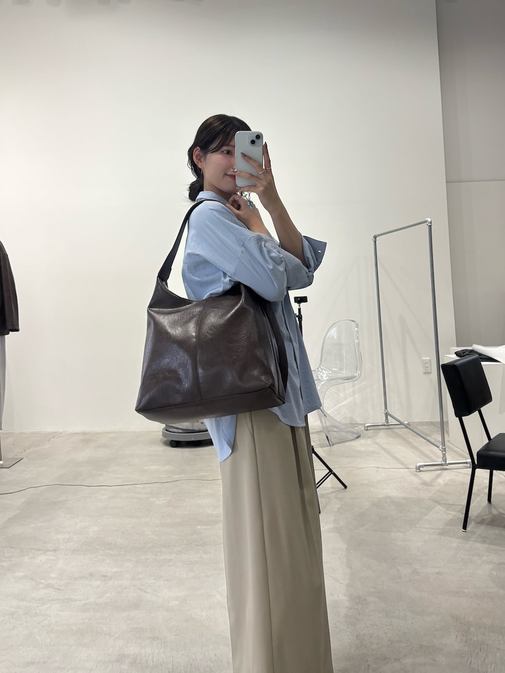 ブルー系のシャツ/ブラウス、ブラウン系のショルダーバッグ、ベージュ系のスラックスを着用したレディースの冬コーディネートの3枚目の写真