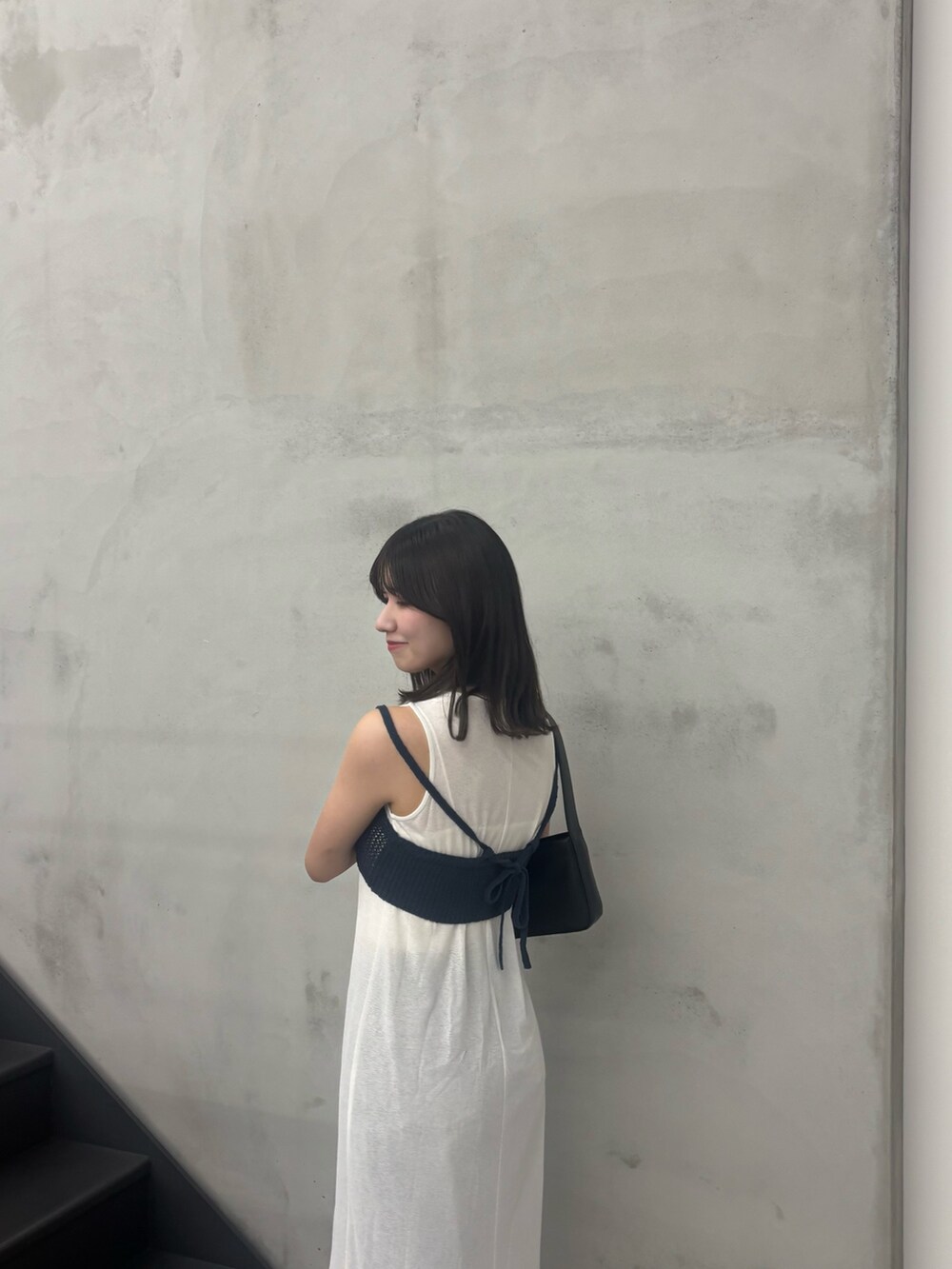 ホワイト系のワンピース、ブルー系のデニムパンツ、ブルー系のベストを着用したレディースの夏コーディネートの3枚目の写真