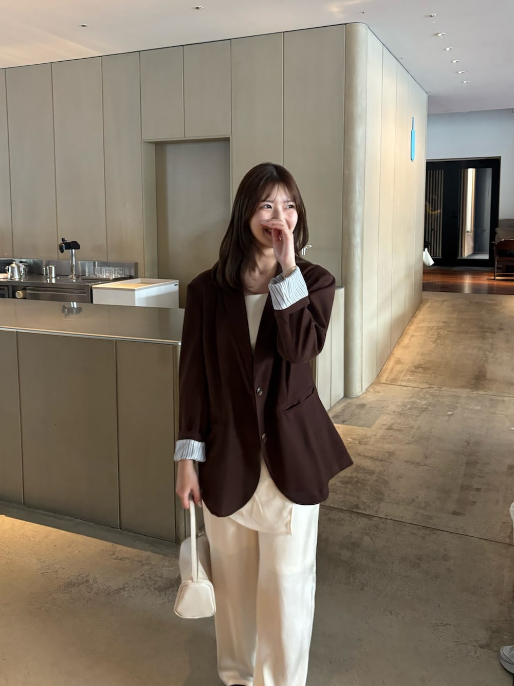 ブラウン系のテーラードジャケット、ホワイト系のその他パンツ、ホワイト系のキャミソールを着用したレディースの冬コーディネートの2枚目の写真