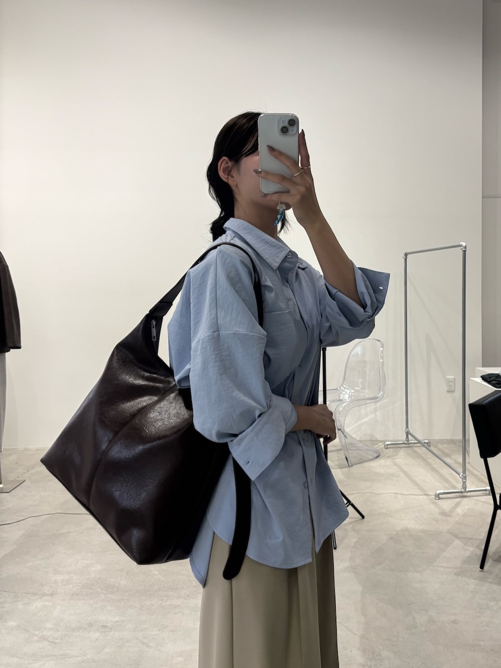 ブルー系のシャツ/ブラウス、ブラウン系のショルダーバッグ、ベージュ系のスラックスを着用したレディースの冬コーディネートの2枚目の写真