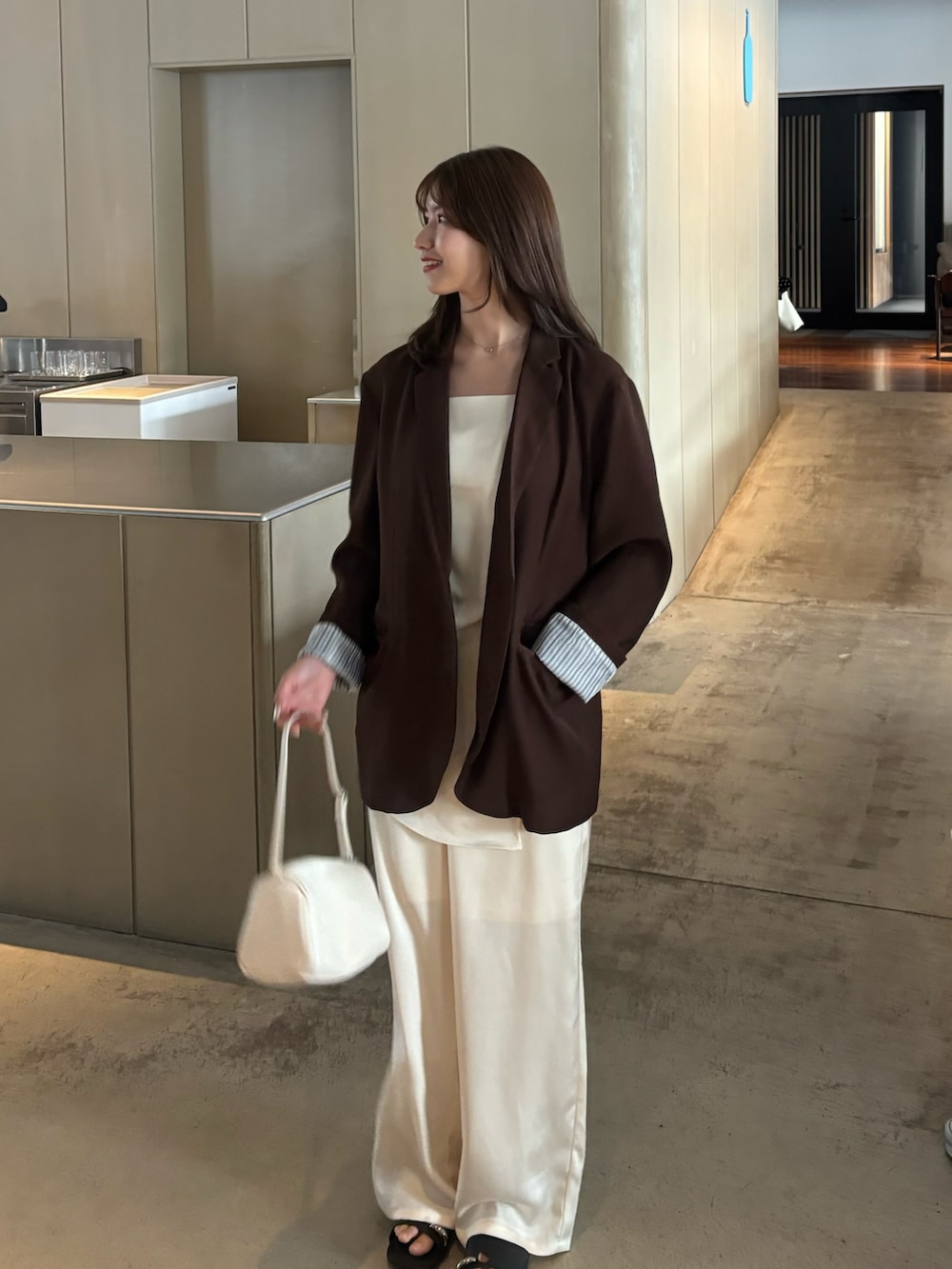 ブラウン系のテーラードジャケット、ホワイト系のその他パンツ、ホワイト系のキャミソールを着用したレディースの冬コーディネートの3枚目の写真