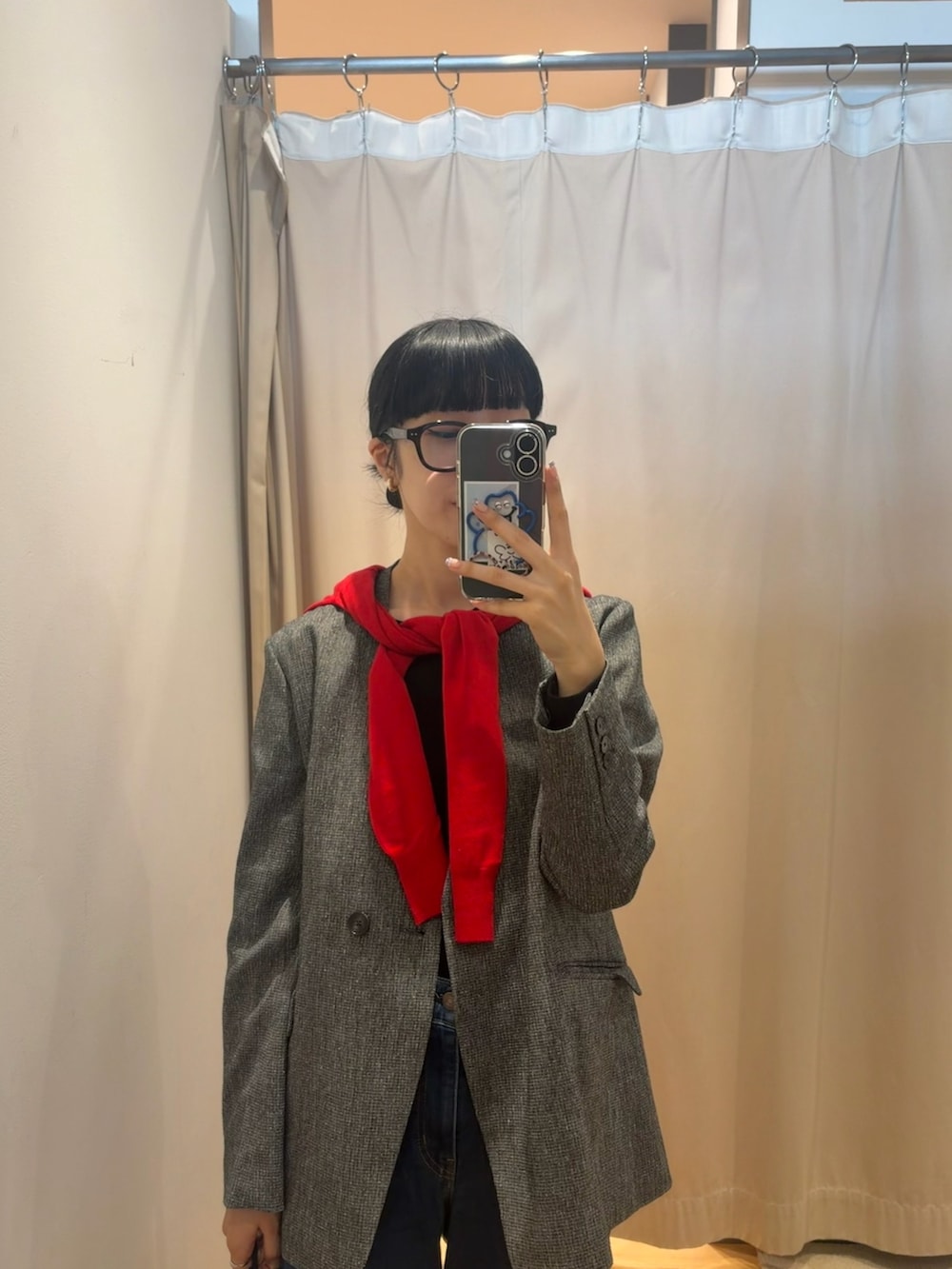 レッド系のカーディガン/ボレロ、ブルー系のデニムパンツ、ブラック系のショルダーバッグを着用したレディースの秋コーディネートの2枚目の写真