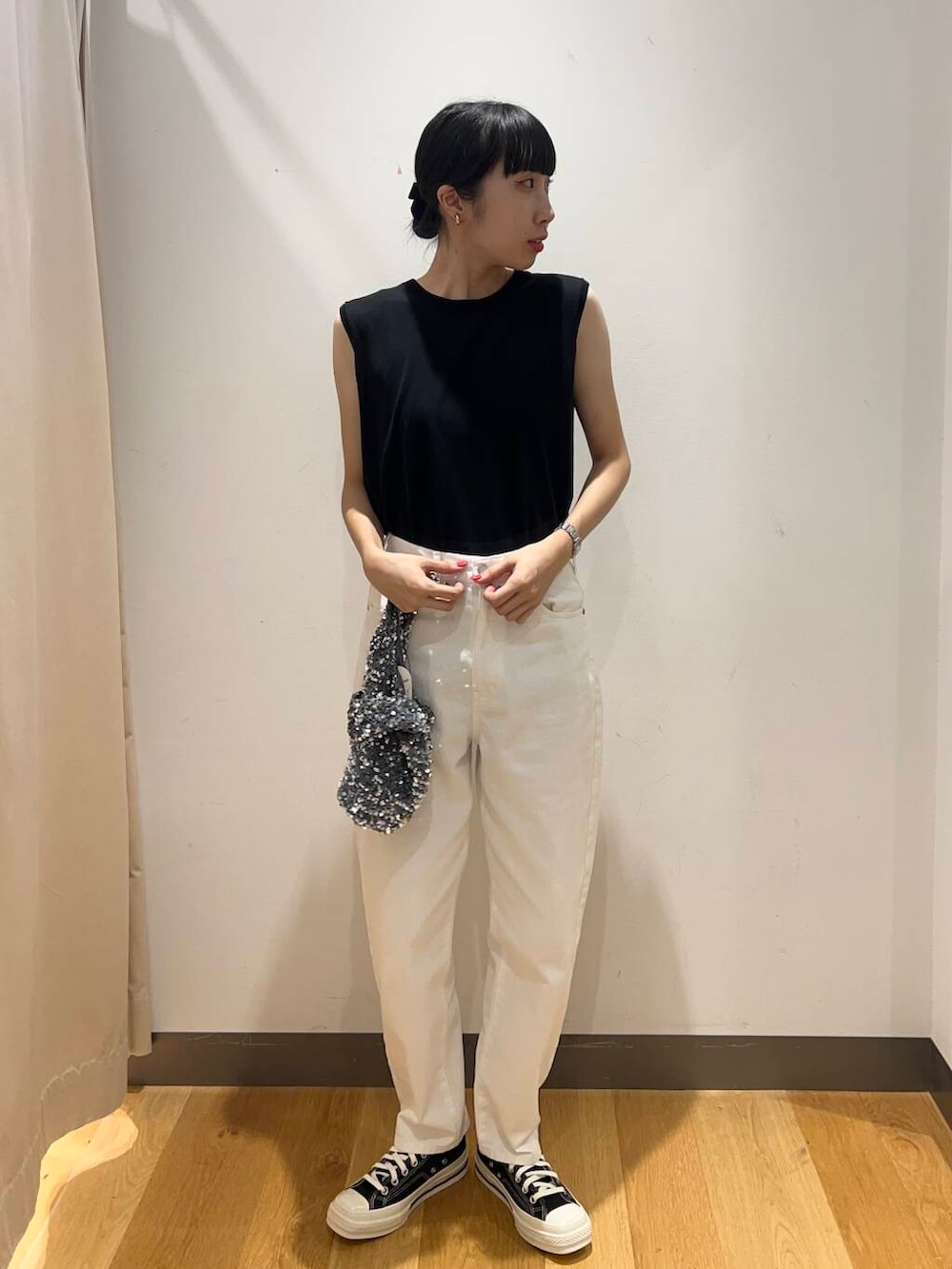 シルバー系のハンドバッグ、ブラック系のその他アウター、ホワイト系のデニムパンツを着用したレディースの夏コーディネートの5枚目の写真