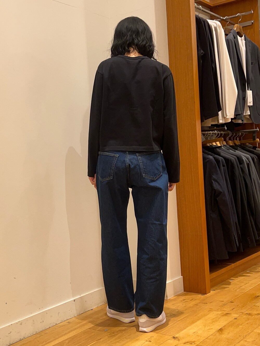 ブラック系のカーディガン/ボレロ、グレー系のスニーカー、ブルー系のデニムパンツを着用したレディースの秋コーディネートの4枚目の写真