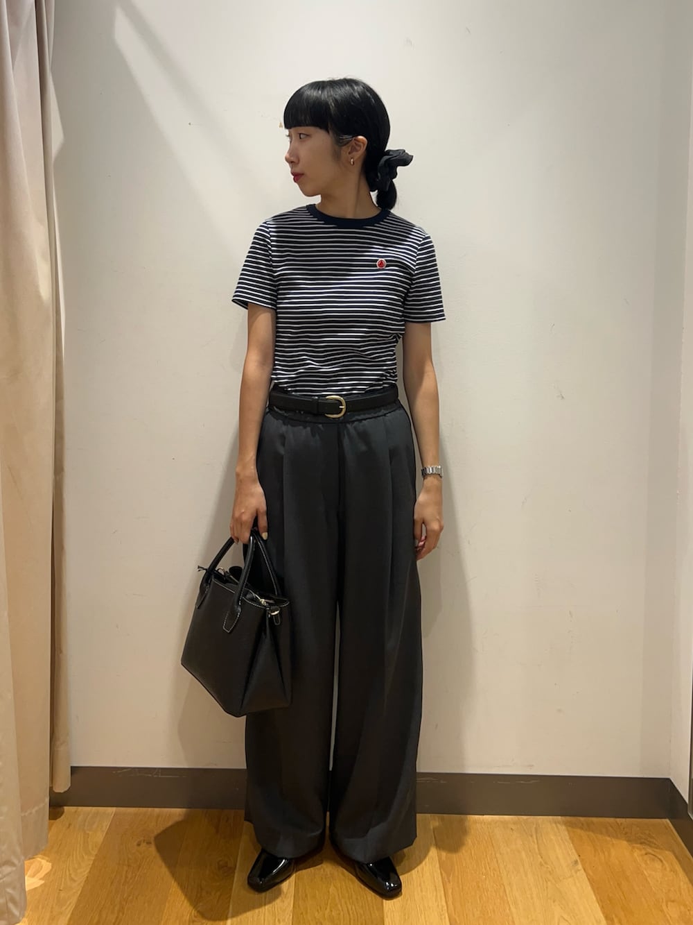 ホワイト系のTシャツ/カットソー、ブラック系のローファー、ブラック系のショルダーバッグを着用したレディースの夏コーディネートの4枚目の写真
