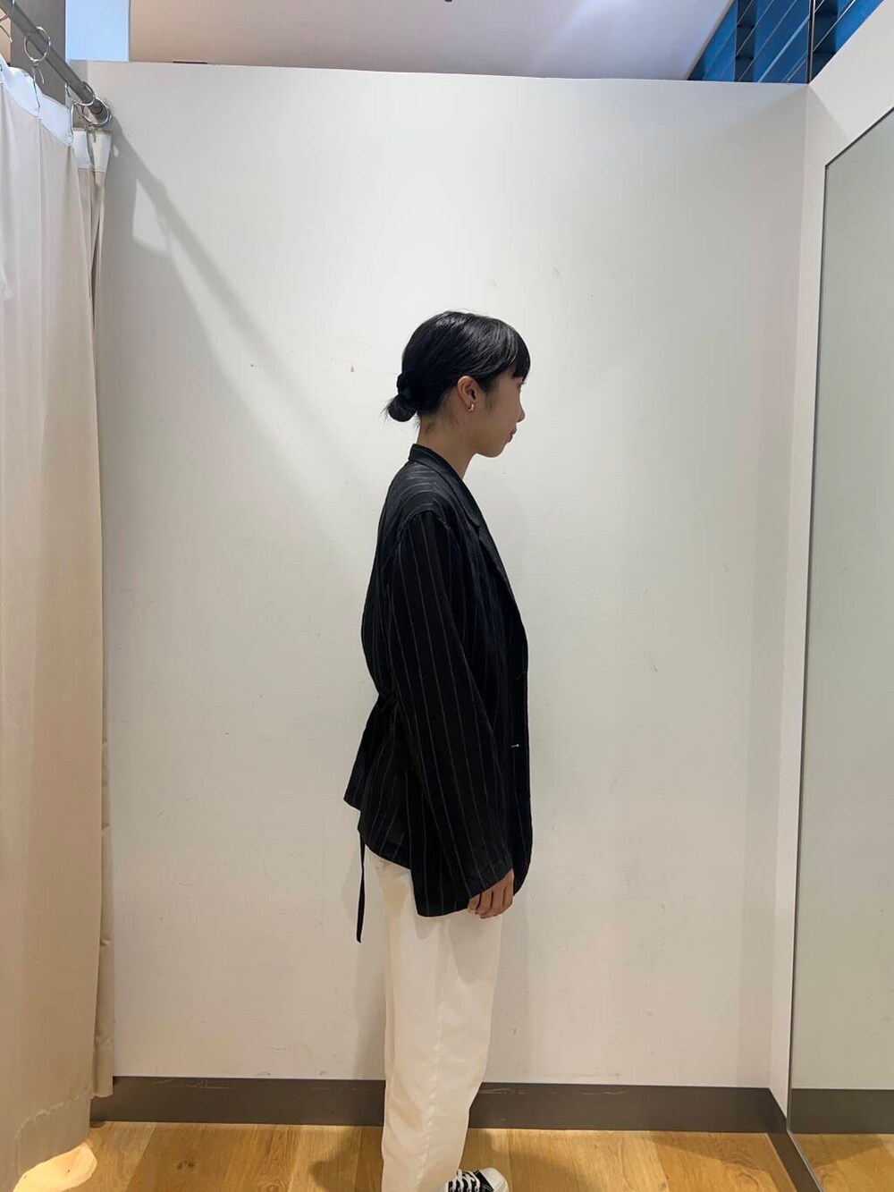 シルバー系のハンドバッグ、ブラック系のその他アウター、ホワイト系のデニムパンツを着用したレディースの夏コーディネートの2枚目の写真