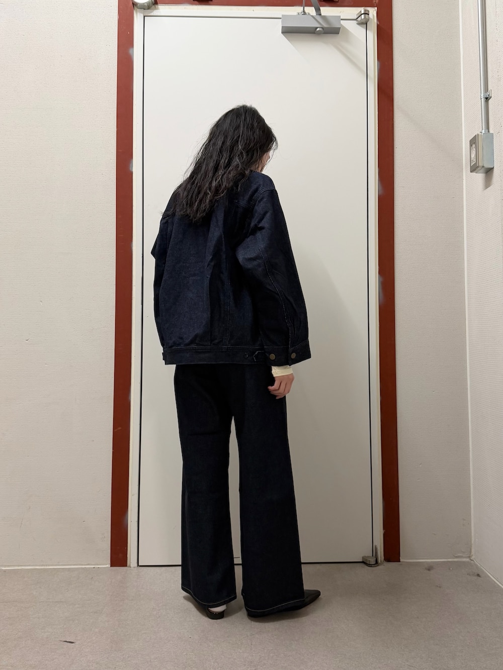 ブルー系のデニムジャケット、ブルー系のデニムパンツ、ホワイト系のTシャツ/カットソーを着用したレディースの冬コーディネートの2枚目の写真