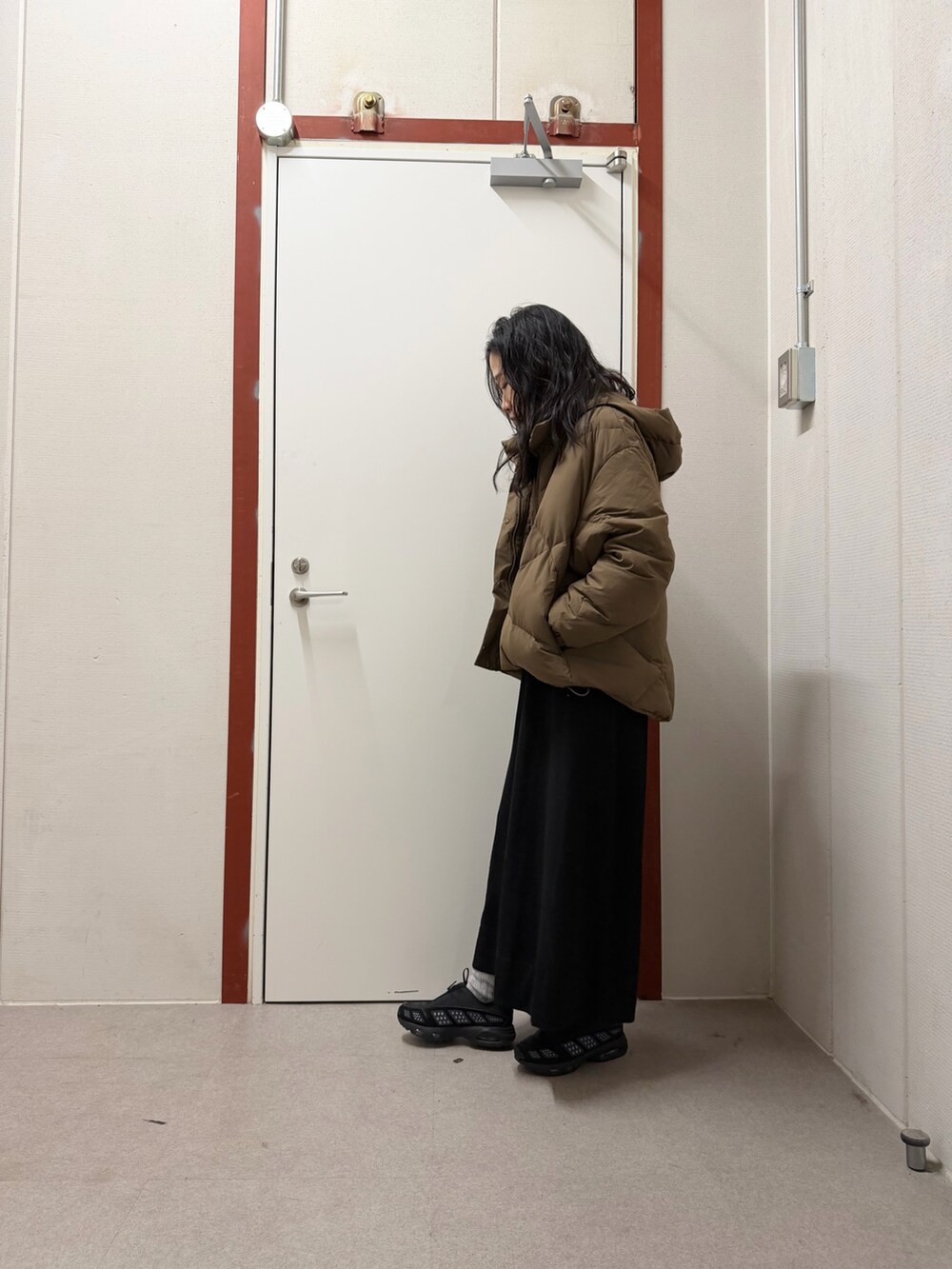 ブラウン系のダウンジャケット/コート、ブラック系のワンピースを着用したレディースの秋コーディネートの2枚目の写真