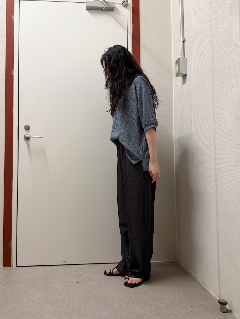 ブルー系のTシャツ/カットソー、ブラック系のデニムパンツ、ブラック系のサンダルを着用したレディースの夏コーディネートの2枚目の写真
