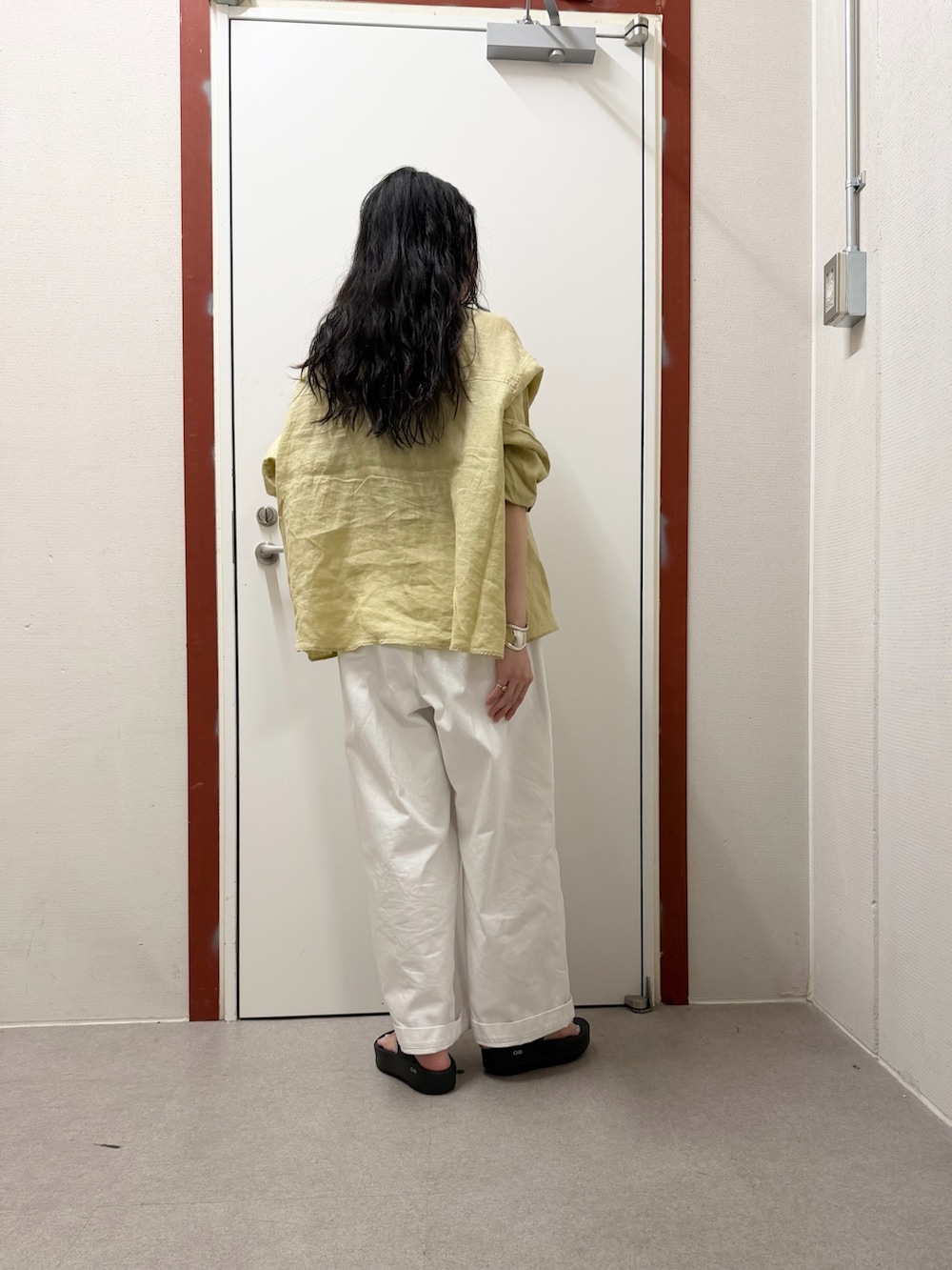 イエロー系のシャツ/ブラウス、ホワイト系のその他パンツ、ブラック系のサンダルを着用したレディースの春コーディネートの2枚目の写真