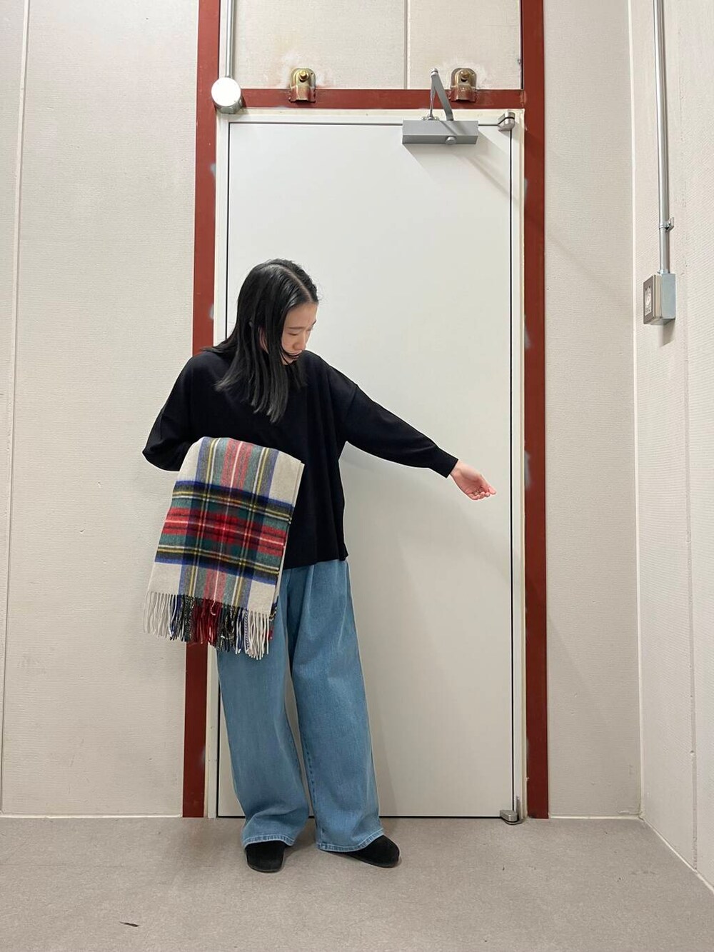 ブラック系のニット/セーター、ブラック系のサンダル、ホワイト系のストール/ショールを着用したレディースの秋コーディネートの3枚目の写真