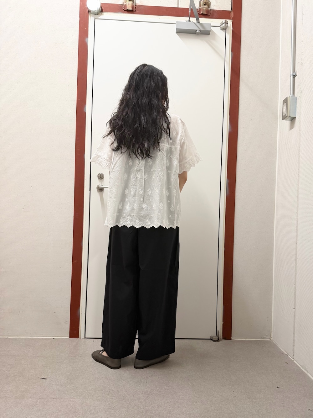 ホワイト系のシャツ/ブラウス、ブラック系のその他パンツ、ベージュ系のハンドバッグを着用したレディースの夏コーディネートの3枚目の写真