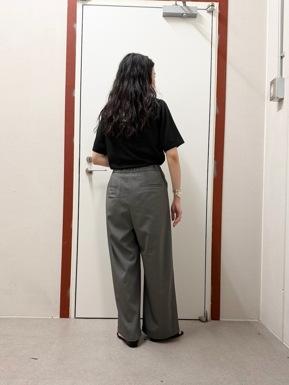 ブラック系のTシャツ/カットソー、グレー系のその他パンツ、ブラック系のサンダルを着用したレディースの春コーディネートの3枚目の写真
