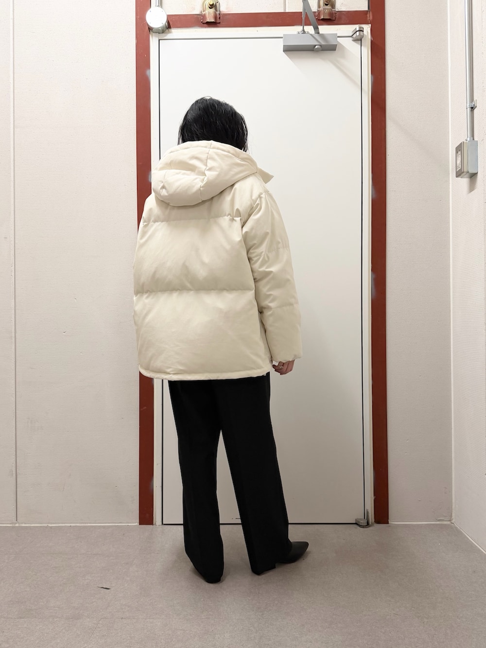 ホワイト系のダウンジャケット/コート、グリーン系のニット/セーター、ブラック系のその他パンツを着用したレディースの冬コーディネートの3枚目の写真