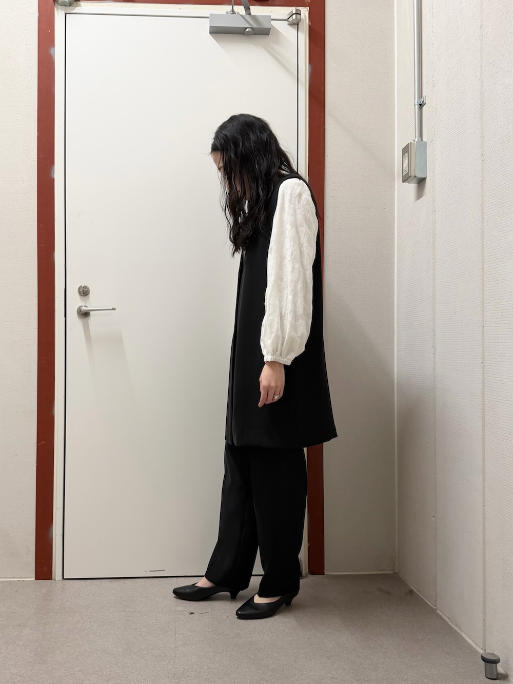 ブラック系のその他パンツ、ブラック系のベスト、ホワイト系のシャツ/ブラウスを着用したレディースの冬コーディネートの2枚目の写真