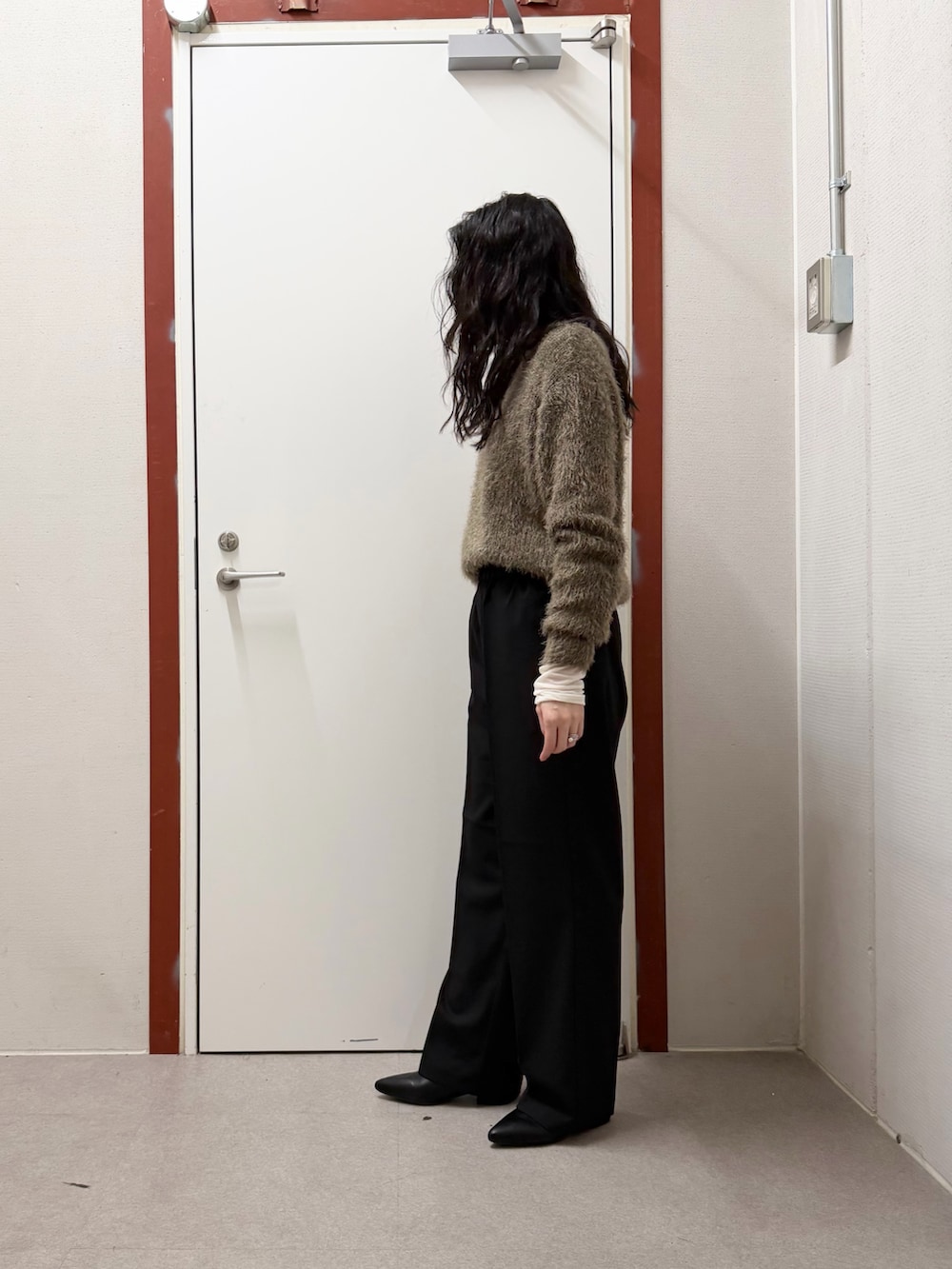 ホワイト系のダウンジャケット/コート、グリーン系のニット/セーター、ブラック系のその他パンツを着用したレディースの冬コーディネートの5枚目の写真