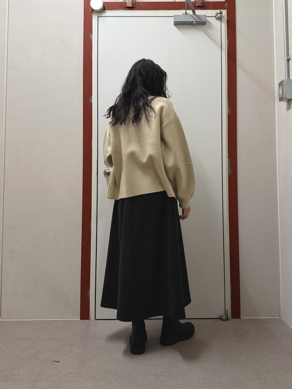 パープル系のニット/セーター、グレー系のスカート、ホワイト系のニット/セーターを着用したレディースの冬コーディネートの3枚目の写真