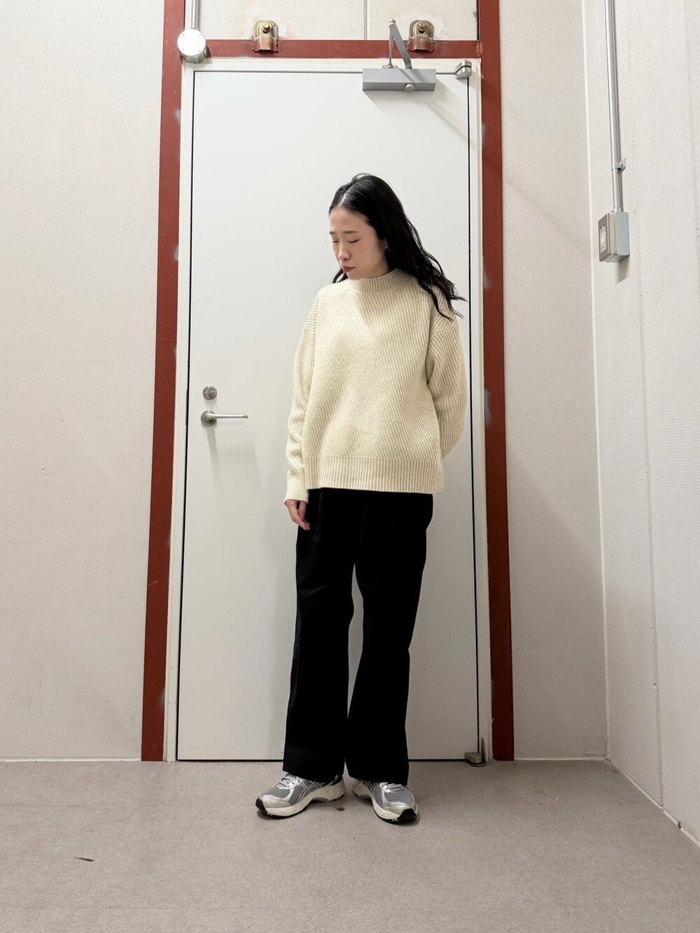 ブルー系のその他アウター、ベージュ系のニット/セーター、ブラック系のその他パンツを着用したレディースの冬コーディネートの2枚目の写真
