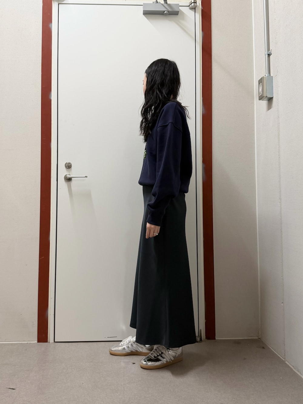 ブルー系のスウェット、ブルー系のスカート、シルバー系のスニーカーを着用したレディースの冬コーディネートの2枚目の写真