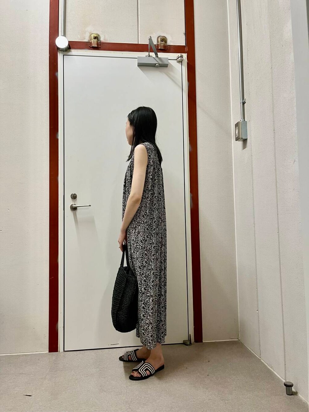 ブラック系のサンダル、ブラック系のワンピースを着用したレディースの夏コーディネートの2枚目の写真