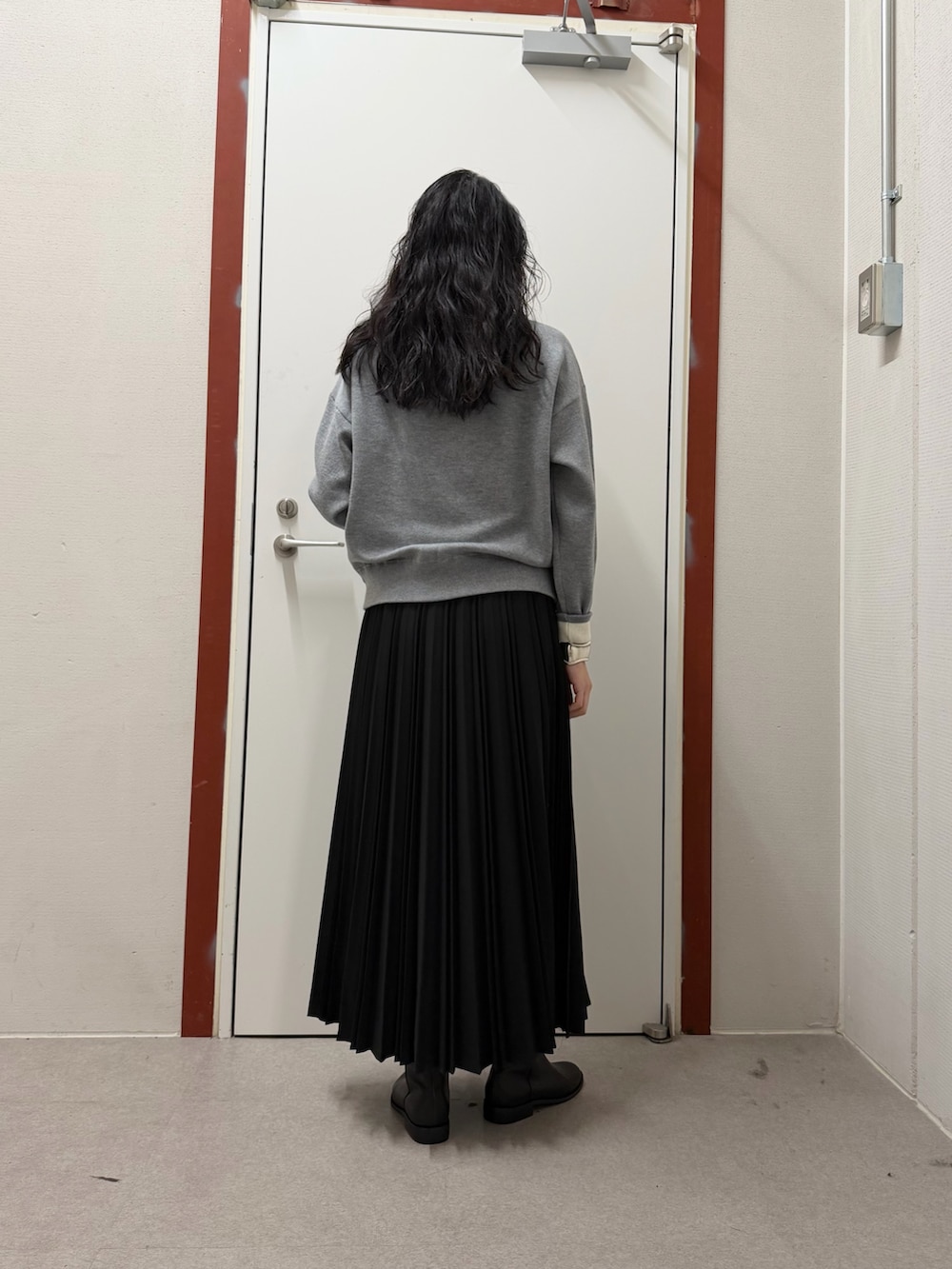 グレー系のニット/セーター、ブラック系のスカートを着用したレディースの冬コーディネートの3枚目の写真