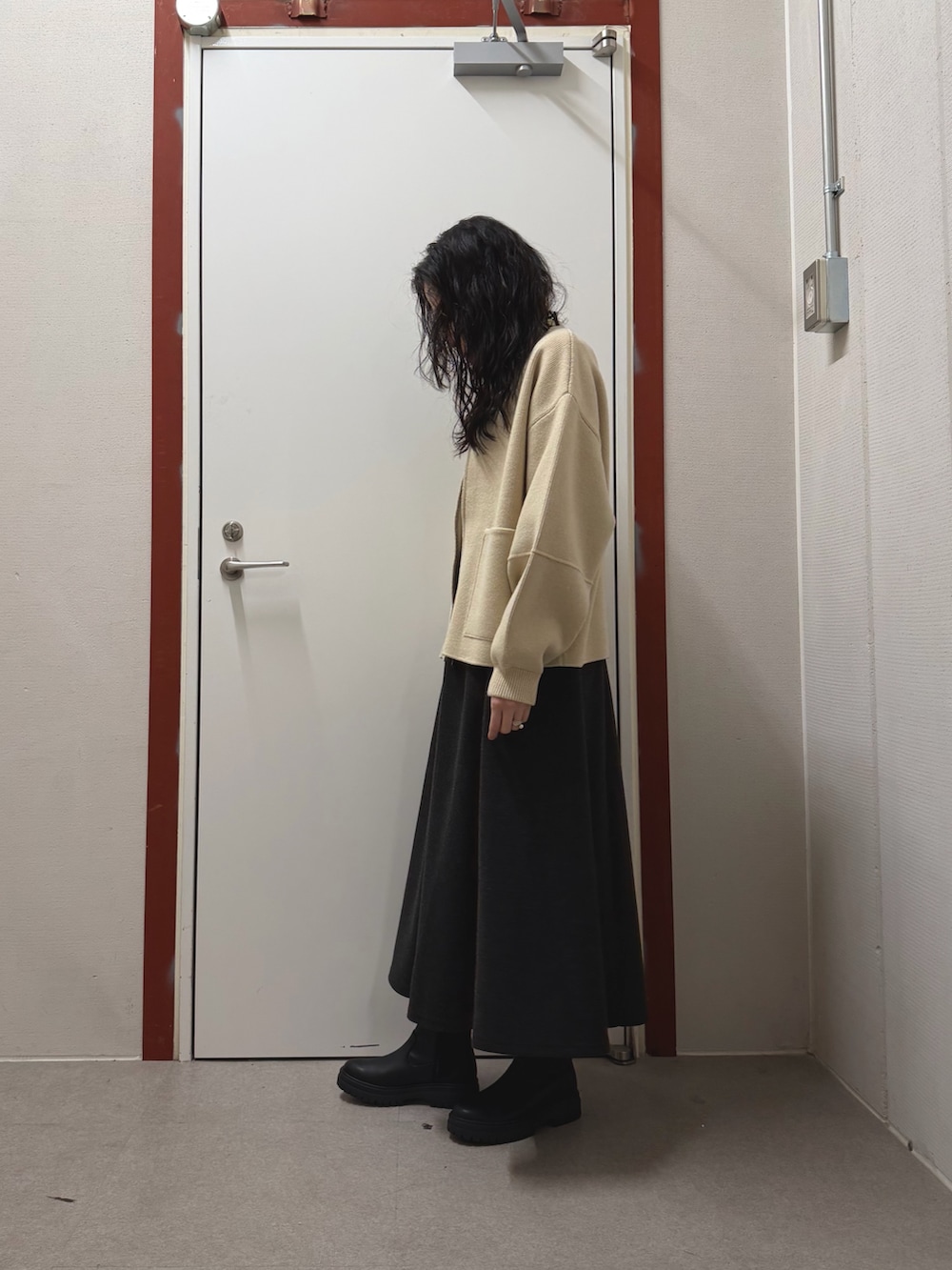 パープル系のニット/セーター、グレー系のスカート、ホワイト系のニット/セーターを着用したレディースの冬コーディネートの2枚目の写真