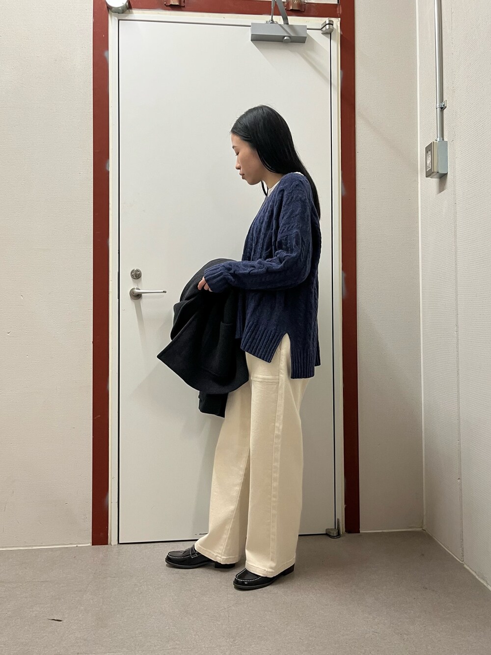 ブルー系のニット/セーター、グレー系のその他アウター、ホワイト系のその他パンツを着用したレディースの秋コーディネートの4枚目の写真