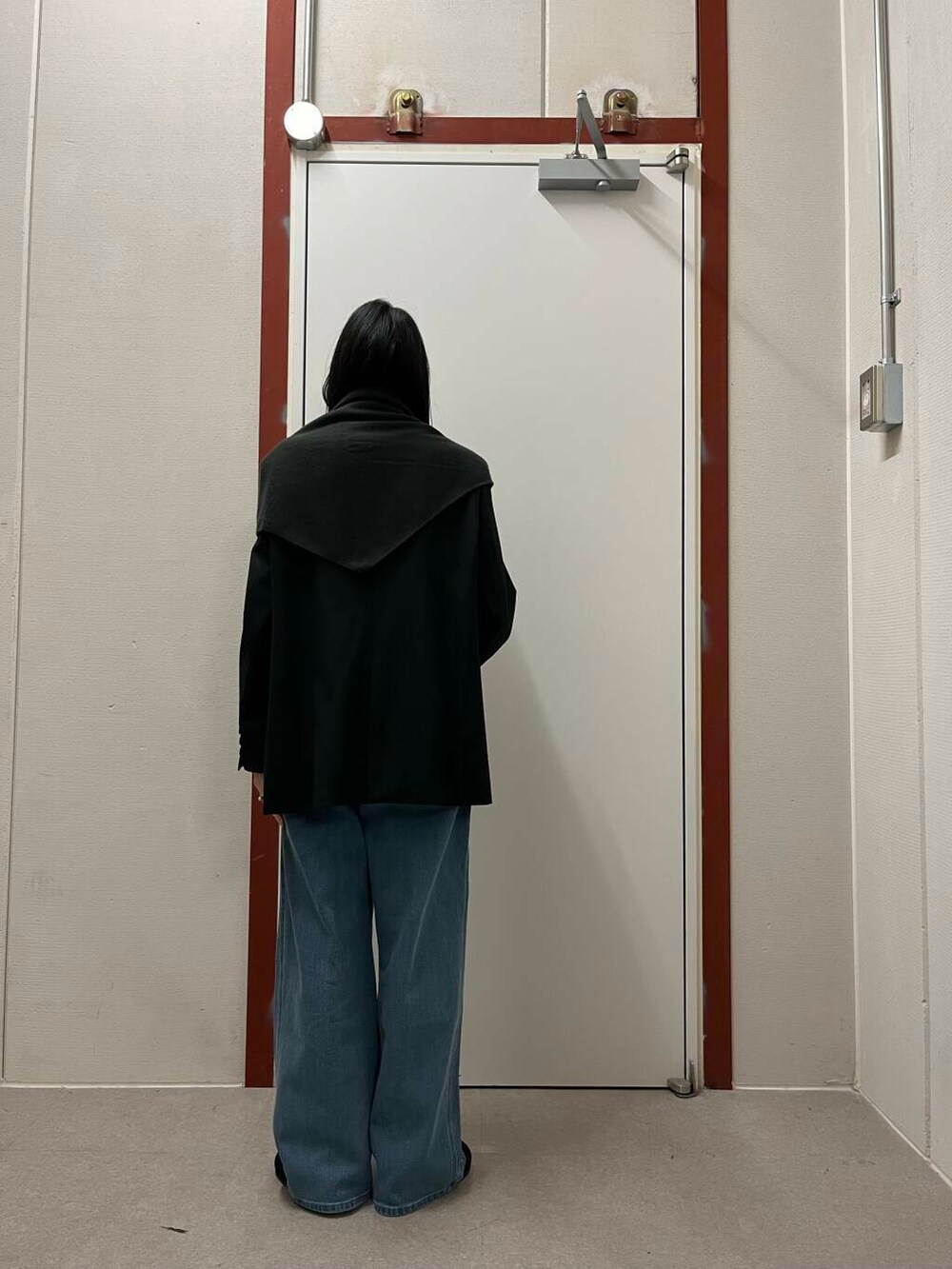 ブラック系のその他アウター、グリーン系のニット/セーター、ブラック系のサンダルを着用したレディースの秋コーディネートの3枚目の写真