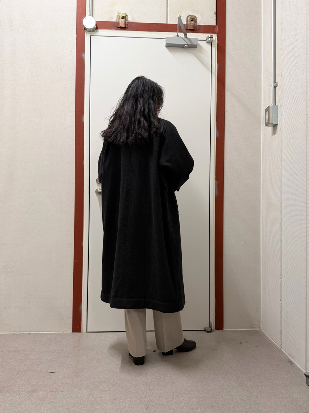 グレー系のステンカラーコート、ベージュ系のニット/セーター、ベージュ系のその他パンツを着用したレディースの秋コーディネートの3枚目の写真