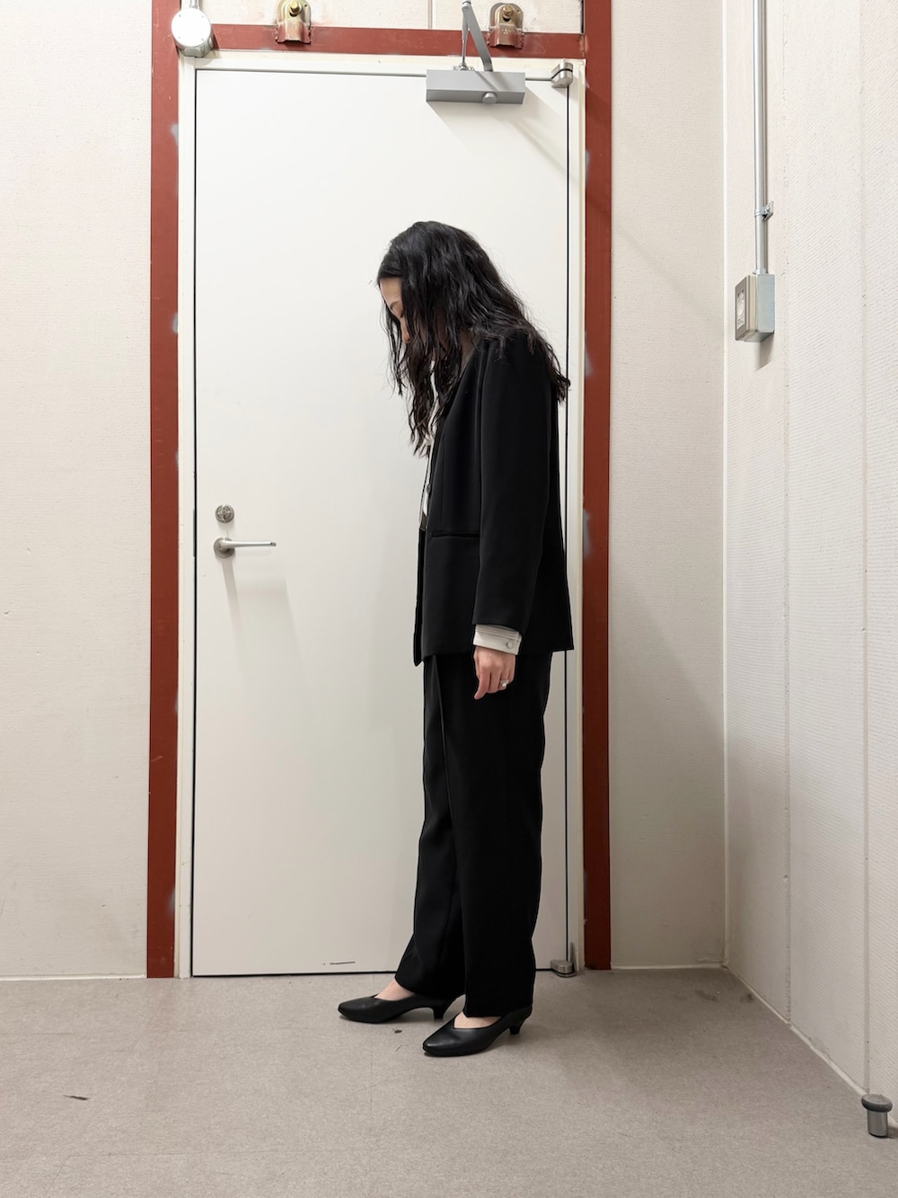 ブラック系のスーツジャケット、ブラック系のその他パンツ、ブラック系のパンプスを着用したレディースの冬コーディネートの2枚目の写真