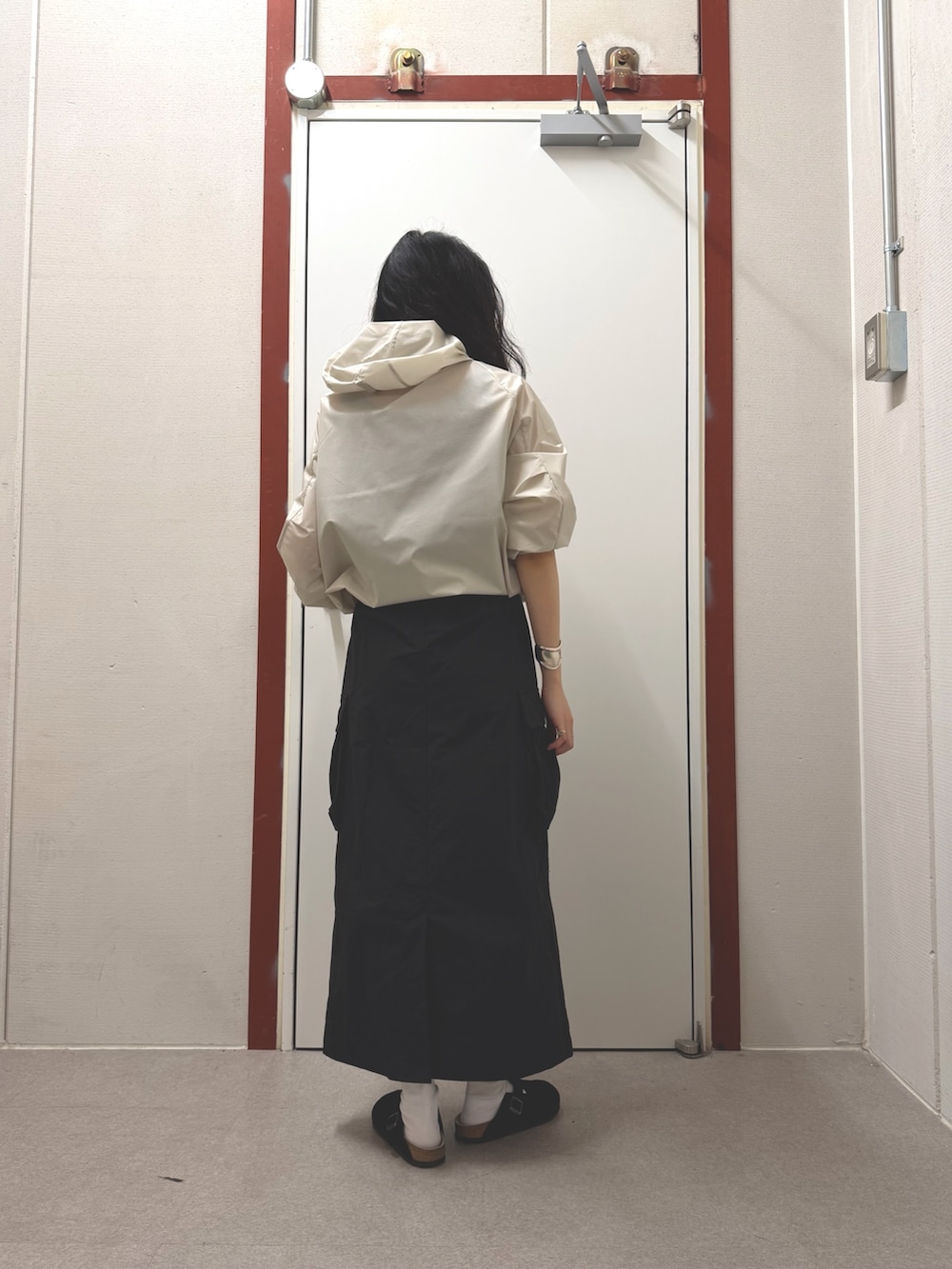 ホワイト系のナイロンジャケット、ブラック系のスカートを着用したレディースの春コーディネートの3枚目の写真