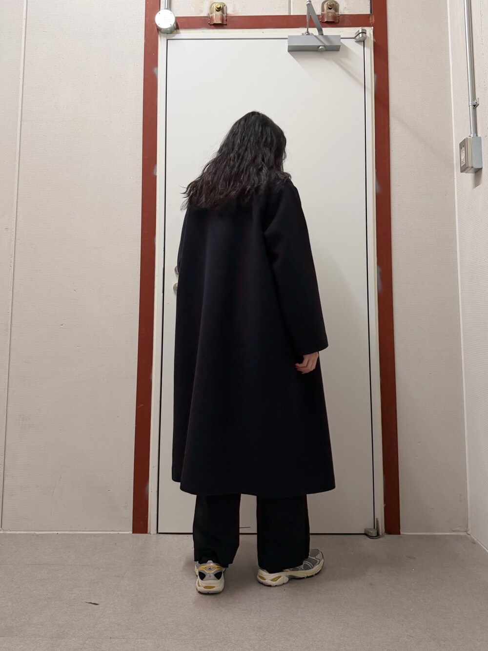 ブルー系のその他アウター、ベージュ系のニット/セーター、ブラック系のその他パンツを着用したレディースの冬コーディネートの3枚目の写真