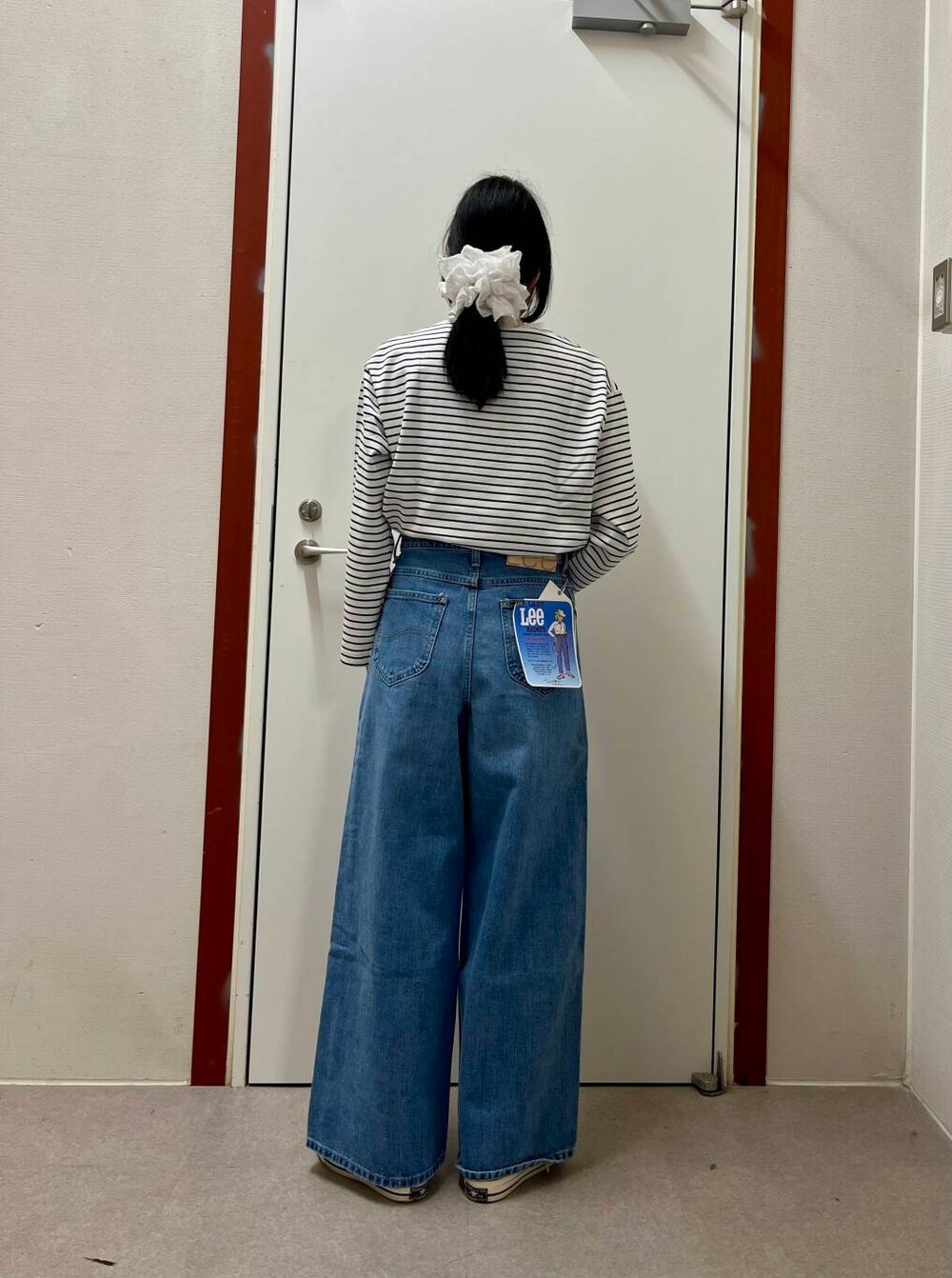 ホワイト系のTシャツ/カットソー、ブルー系のデニムパンツを着用したレディースの春コーディネートの3枚目の写真