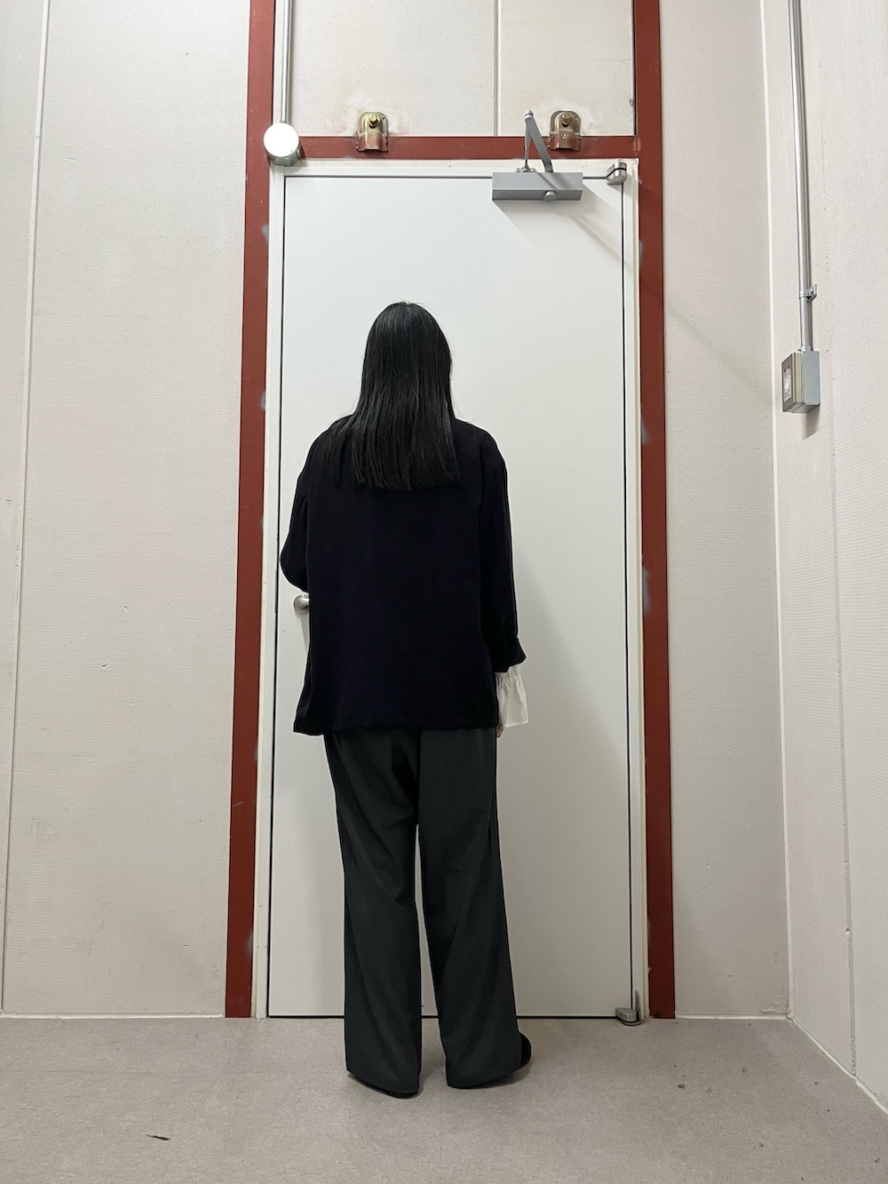 ブラック系のノーカラージャケット、ホワイト系のシャツ/ブラウス、グレー系のその他パンツを着用したレディースの秋コーディネートの3枚目の写真