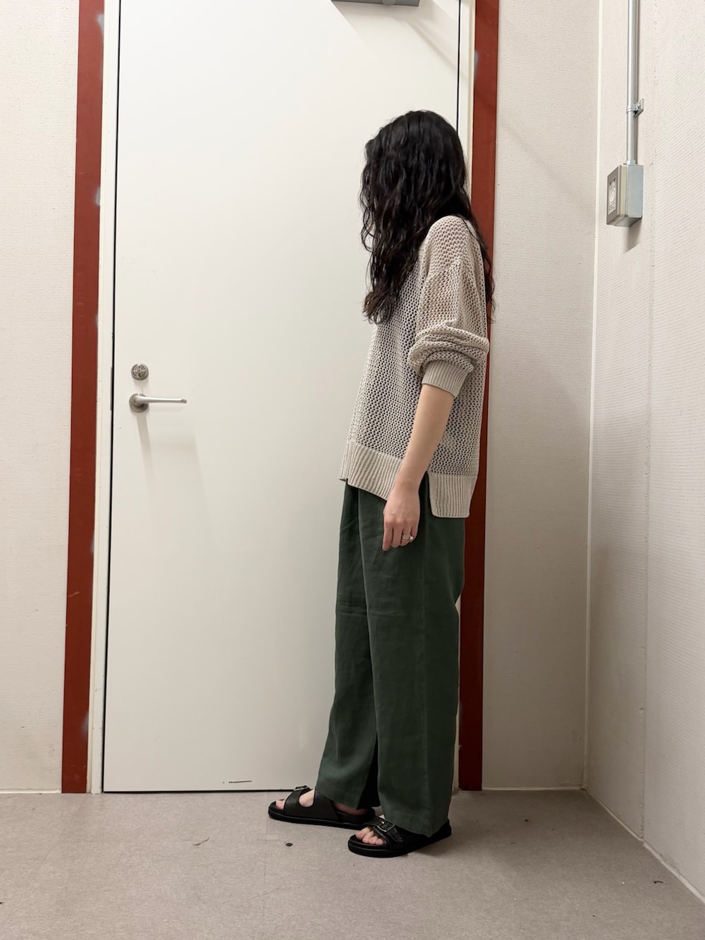 グレー系のニット/セーター、グリーン系のその他パンツ、ブラック系のサンダルを着用したレディースの春コーディネートの2枚目の写真