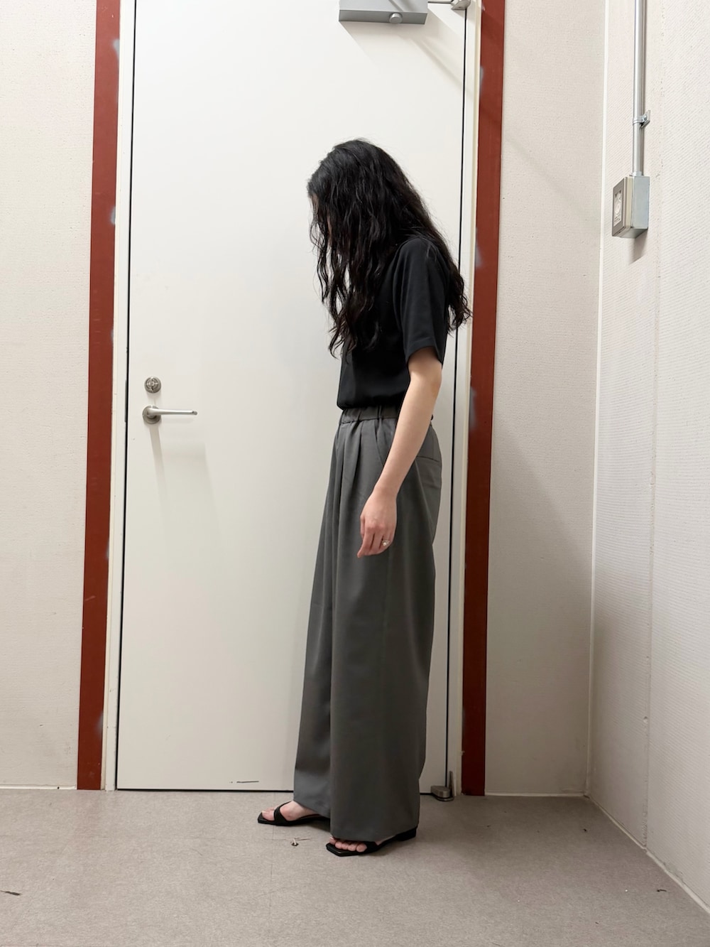 ブラック系のTシャツ/カットソー、グレー系のその他パンツ、ブラック系のサンダルを着用したレディースの春コーディネートの2枚目の写真