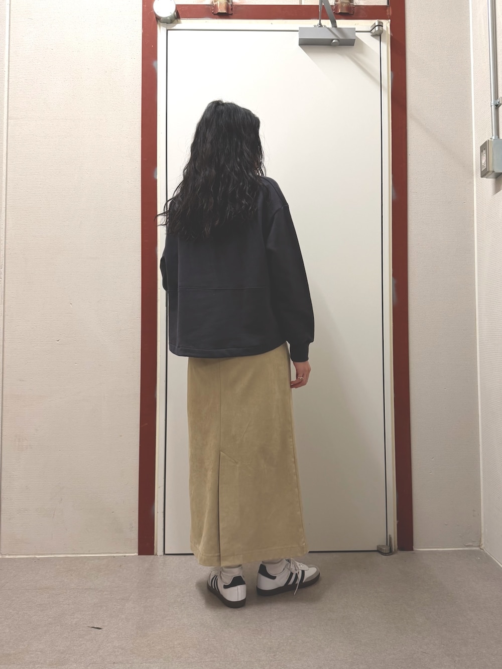 グレー系のスウェット、ホワイト系のスニーカーを着用したレディースの春コーディネートの2枚目の写真