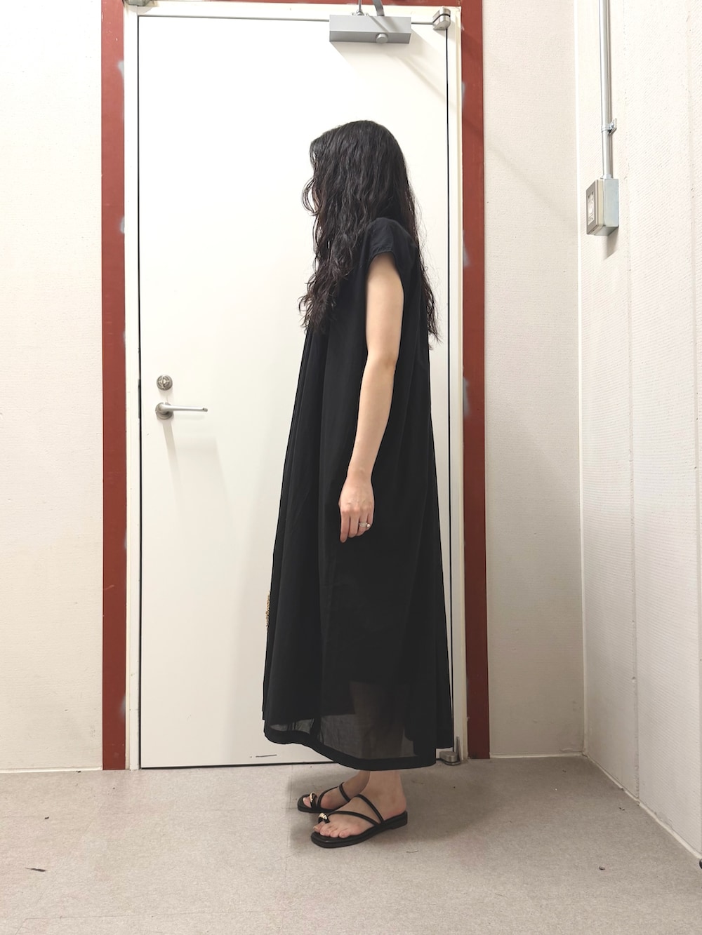 ブラック系のワンピース、ブラック系のサンダルを着用したレディースの夏コーディネートの2枚目の写真