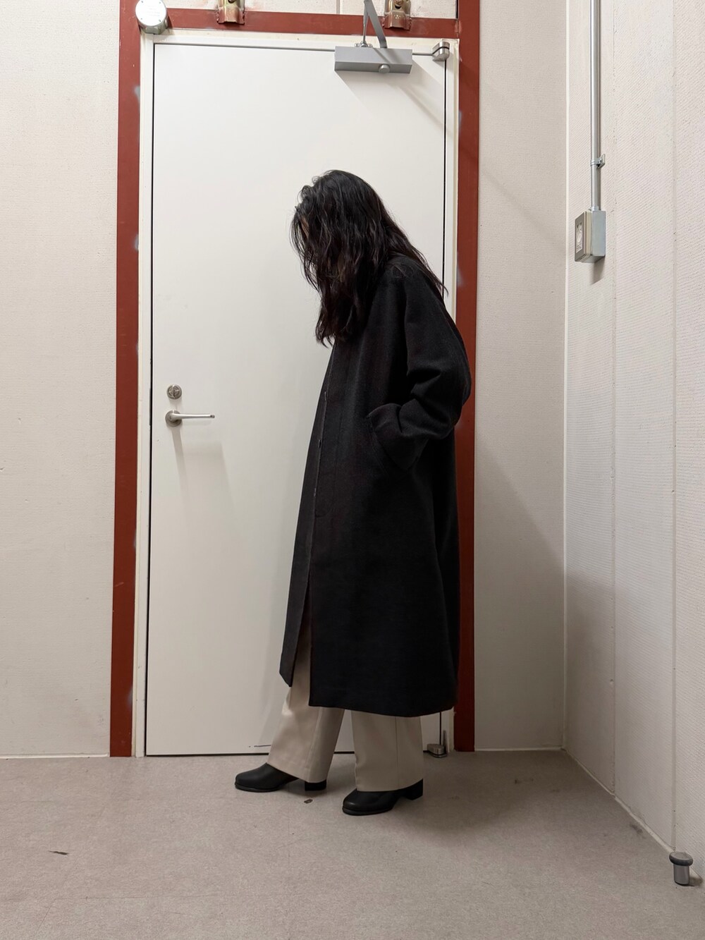 グレー系のステンカラーコート、ベージュ系のニット/セーター、ベージュ系のその他パンツを着用したレディースの秋コーディネートの2枚目の写真