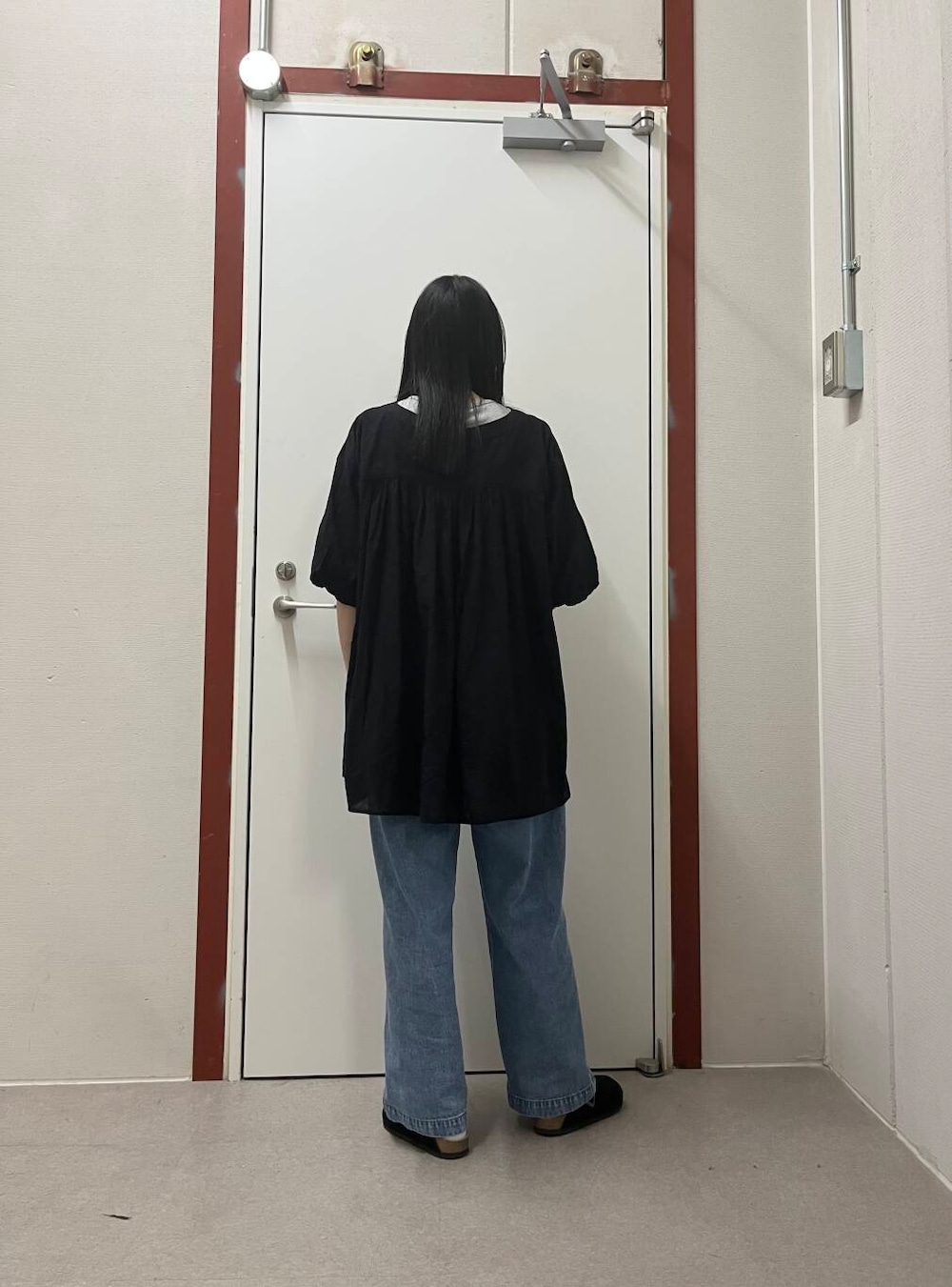 ブルー系のデニムパンツ、ブラック系のチュニックを着用したレディースの夏コーディネートの3枚目の写真