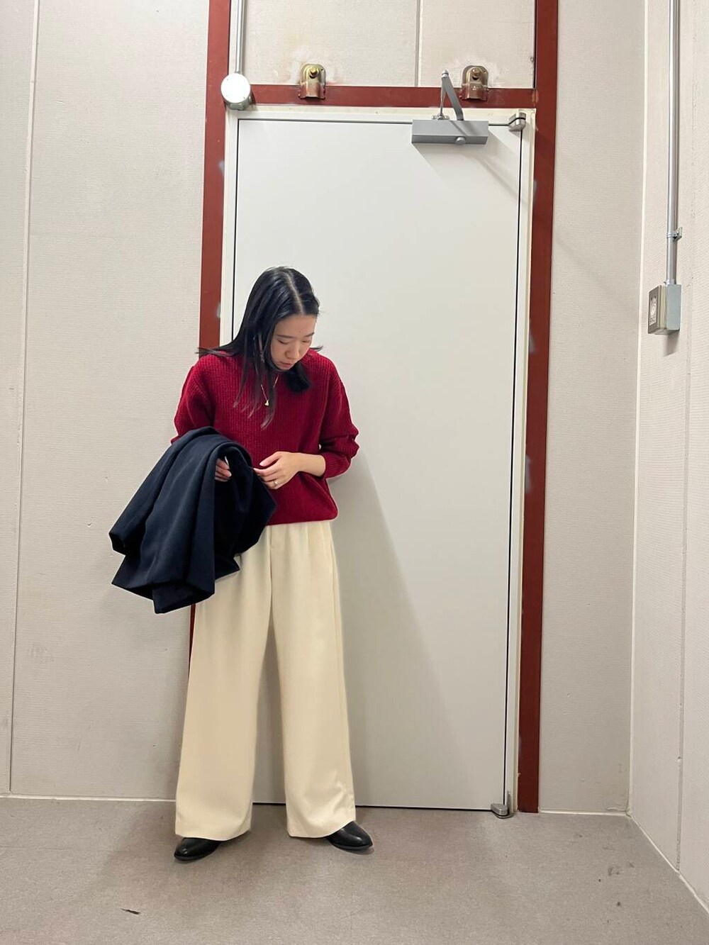 ブラック系のブーツ、レッド系のニット/セーター、ホワイト系のその他パンツを着用したレディースの冬コーディネートの2枚目の写真