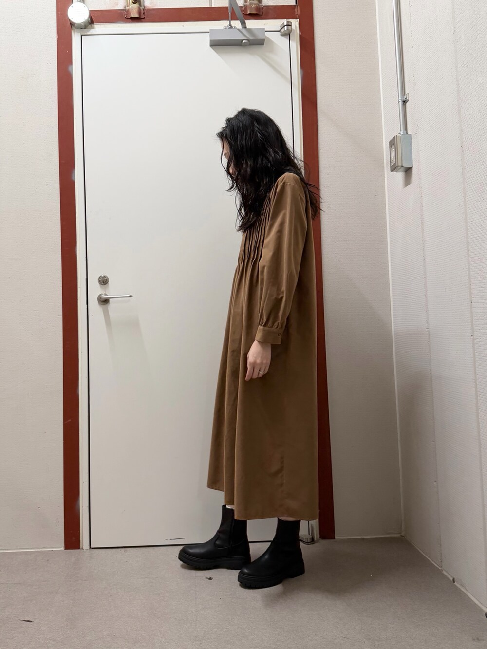 イエロー系のワンピースを着用したレディースの冬コーディネートの2枚目の写真