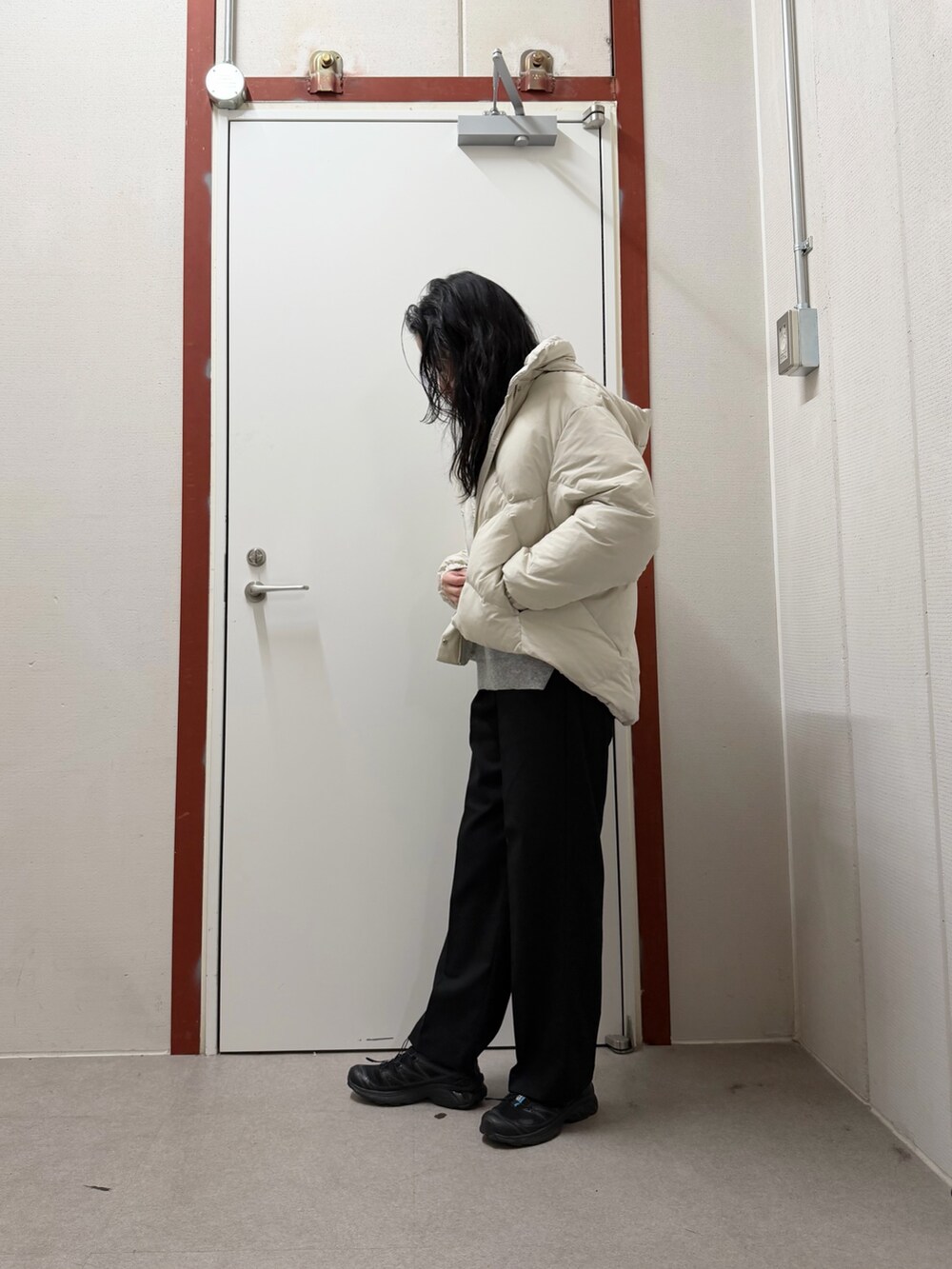 ホワイト系のダウンジャケット/コート、グレー系のニット/セーター、ブラック系のその他パンツを着用したレディースの冬コーディネートの2枚目の写真