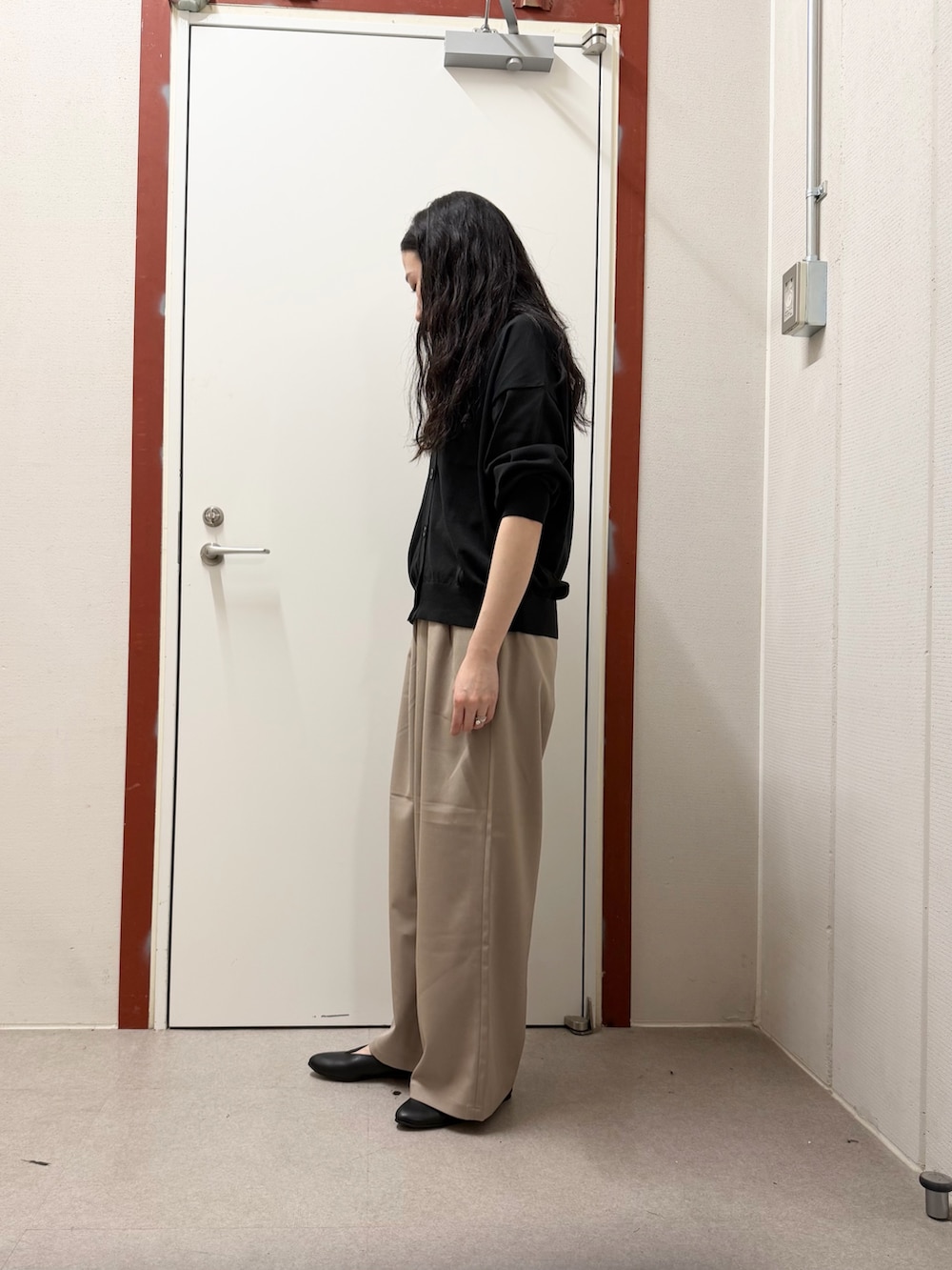 ベージュ系のその他パンツ、ブラック系のパンプス、ブラック系のカーディガン/ボレロを着用したレディースの春コーディネートの2枚目の写真