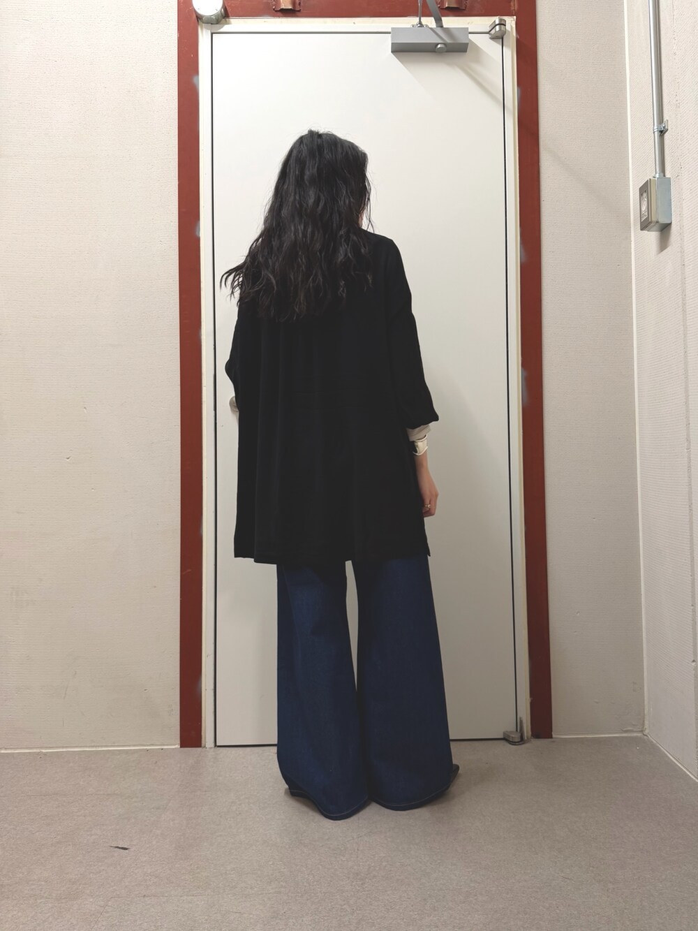 ブラック系のその他トップス、ブルー系のデニムパンツを着用したレディースの春コーディネートの3枚目の写真